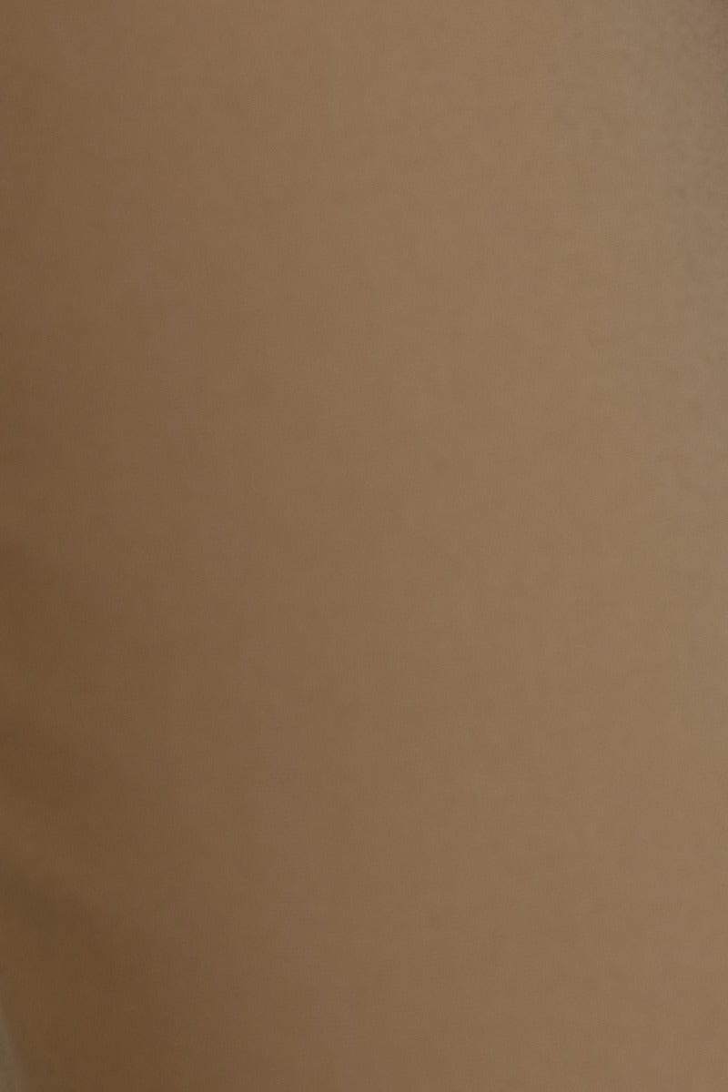 Close-up of Kaniva Pants, showcasing the smooth, light brown fabric with a stylish finish.