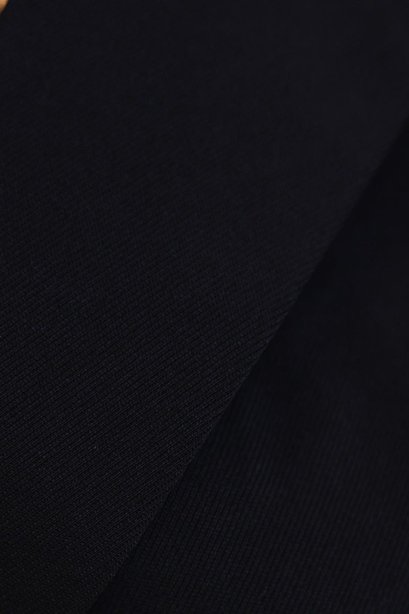 Close-up of black polyester fabric showcasing the texture for the Zeva Blazer.