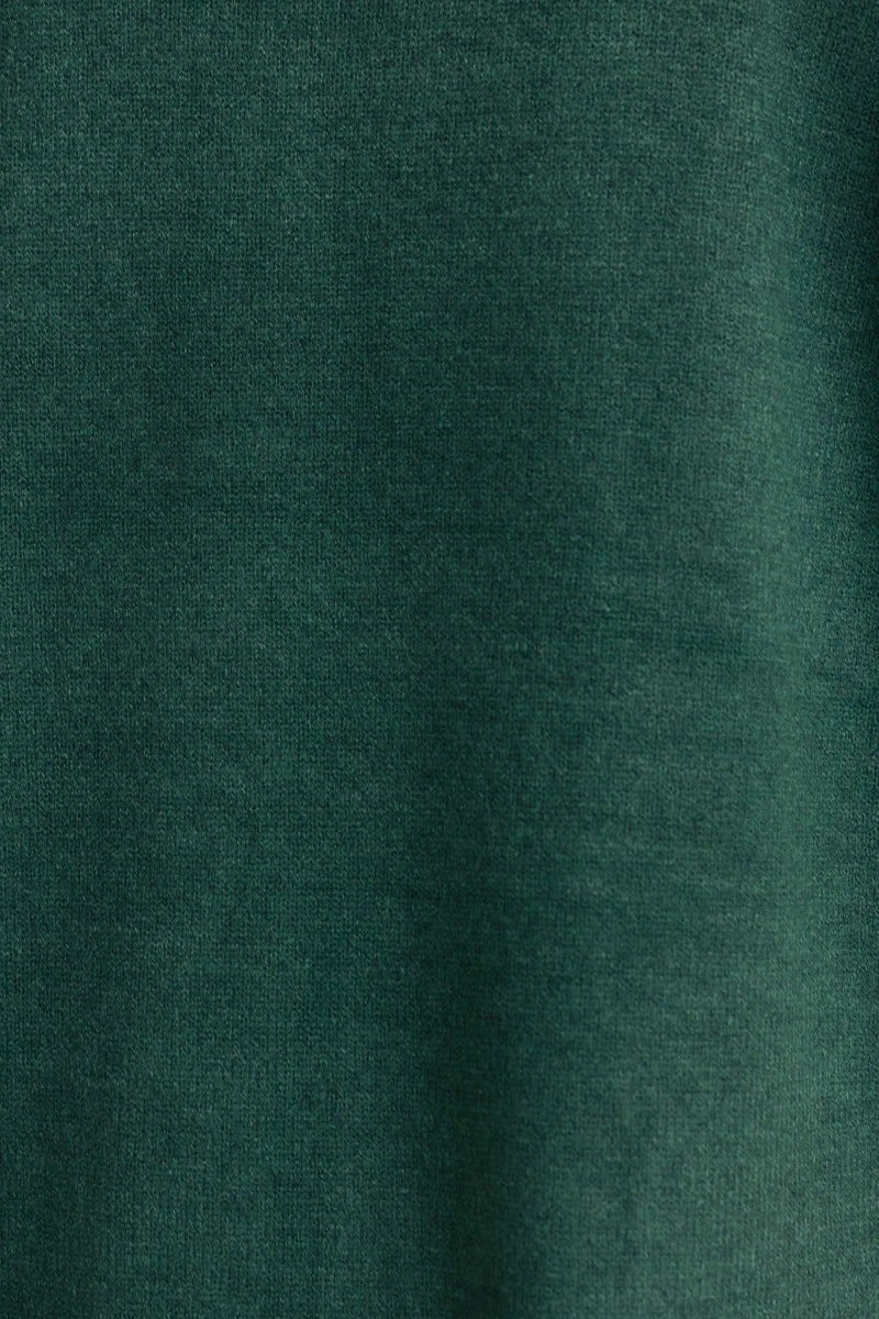 Close-up of dark green ribbed knit fabric, showcasing the soft texture of a Motherly Cardigan.