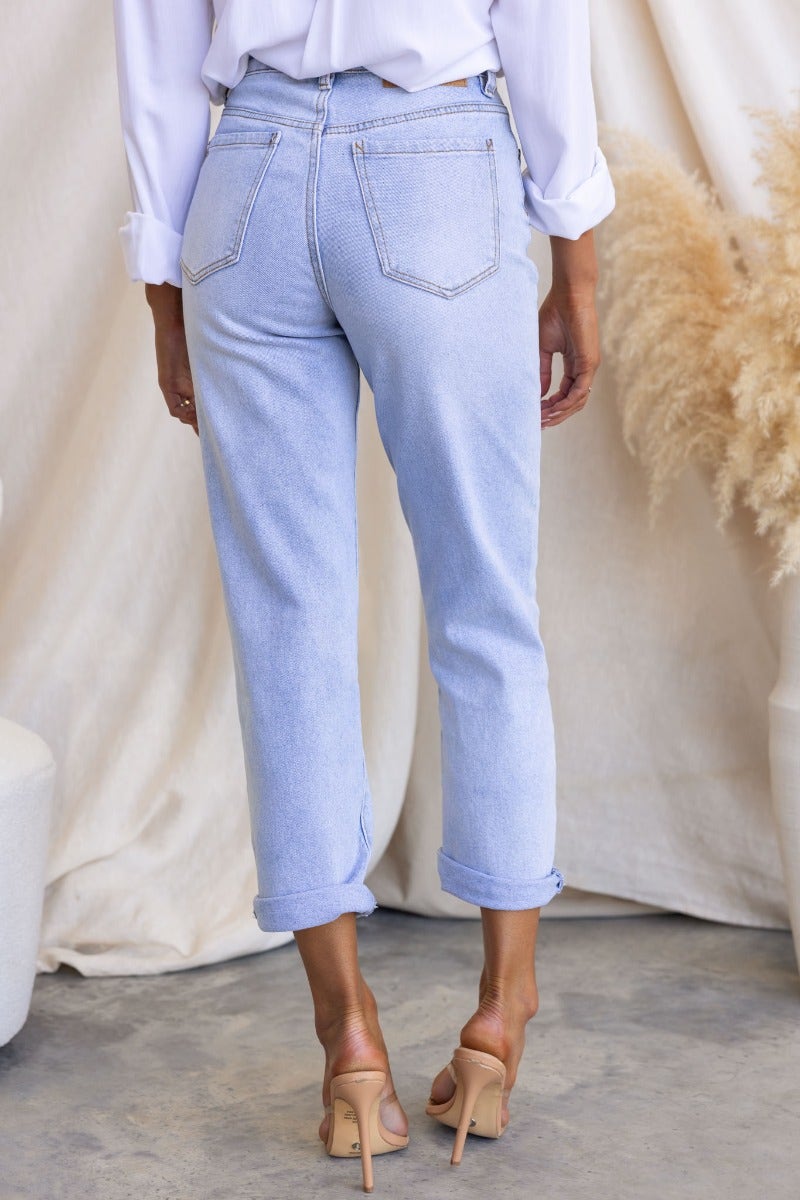Back view of Isoka jeans, mid-high waist denim with pockets and firm stretch, styled with a white blouse.