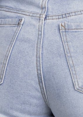 Close-up of Isoka jeans featuring mid-high waist and back pockets in light wash denim.