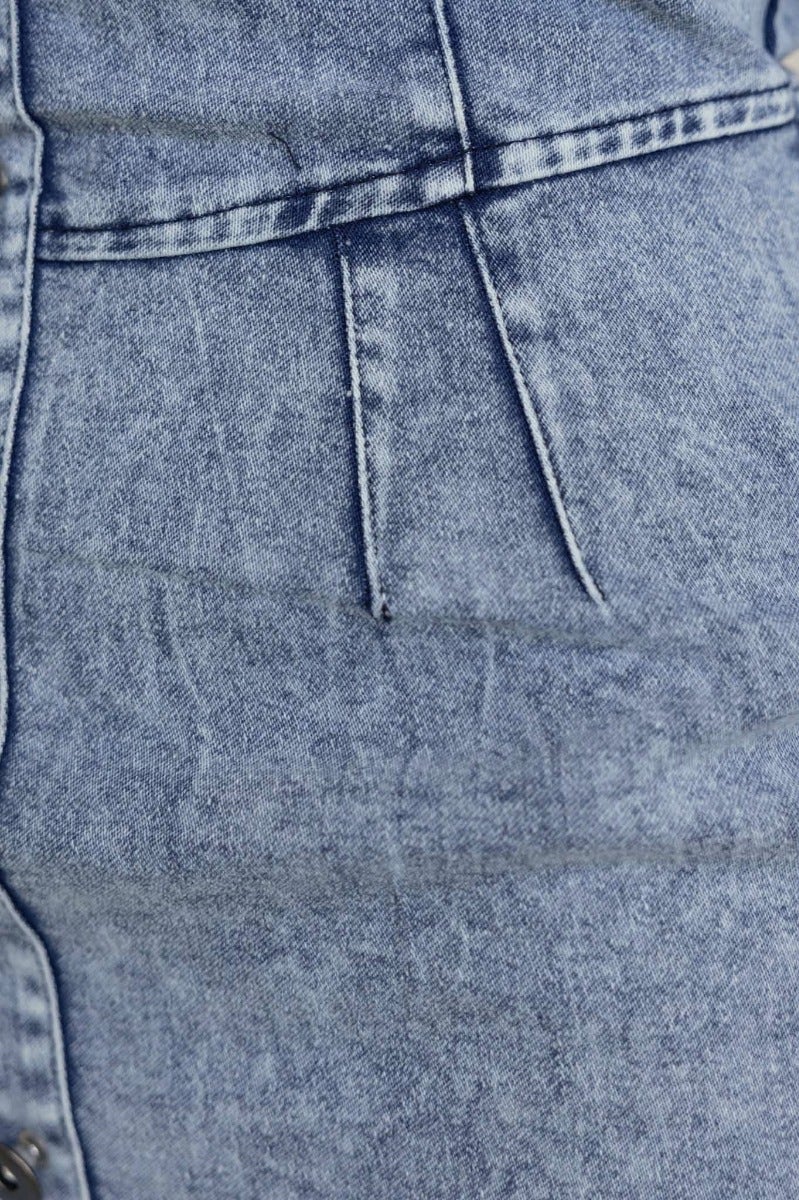 Close-up of the textured denim fabric of the Terese Denim Dress showcasing its unique wash and stitching details.
