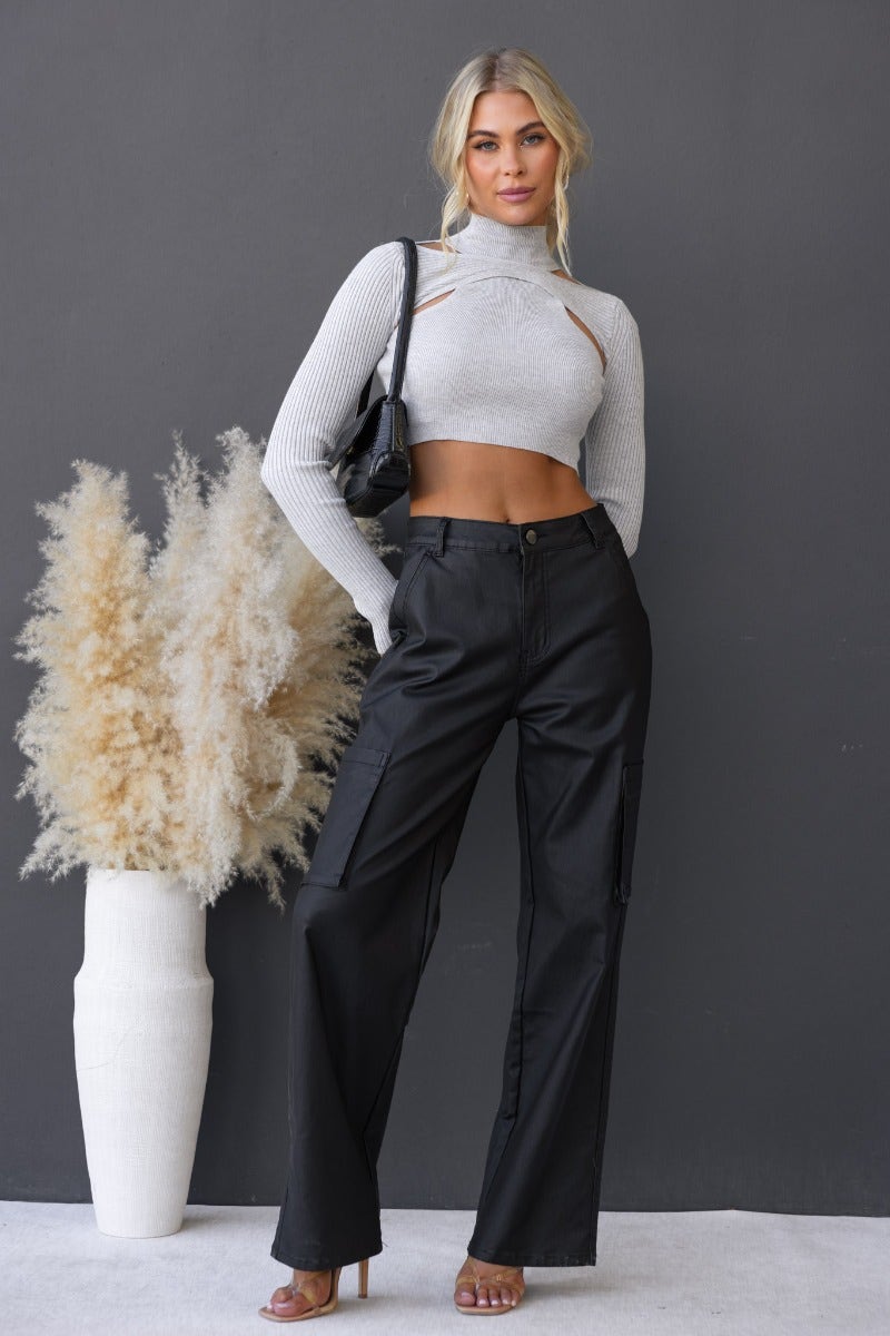 Model wearing a ribbed knit Genova top with cut-outs, paired with black wide-leg pants against a neutral backdrop.