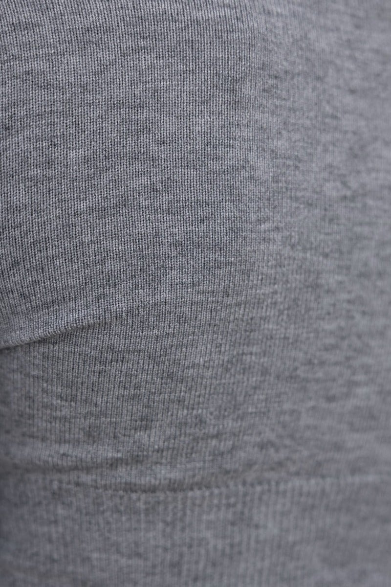 Close-up of the ribbed knit texture of a grey top, showcasing its soft, stretchy fabric.