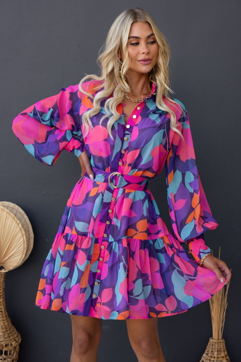Model wearing the Orazio Dress, a multi-colour print dress with high neckline and button-up front, styled with a removable belt.