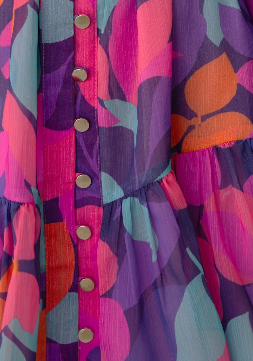 Close-up of Orazio Dress with colorful floral print and button-up front design, showcasing vibrant hues and relaxed fit.