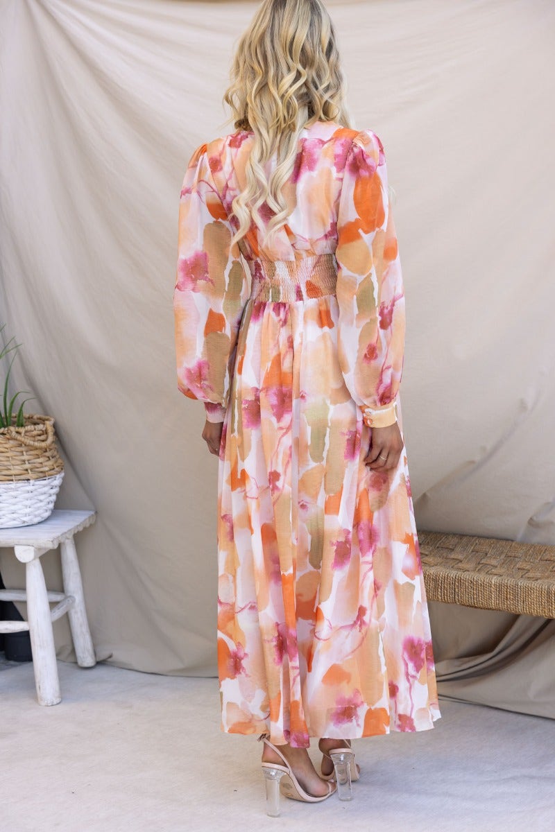 Back view of a multi-colour maxi dress with V-neckline, elastic waistband, and flowing design, perfect for summer events.