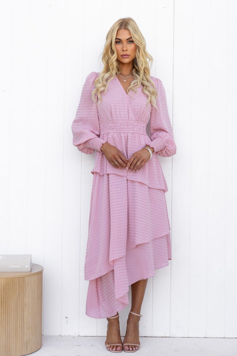 Briena Midi Dress in light pink with V-neckline, elastic waistband, and multi-tier ruffle skirt on model.