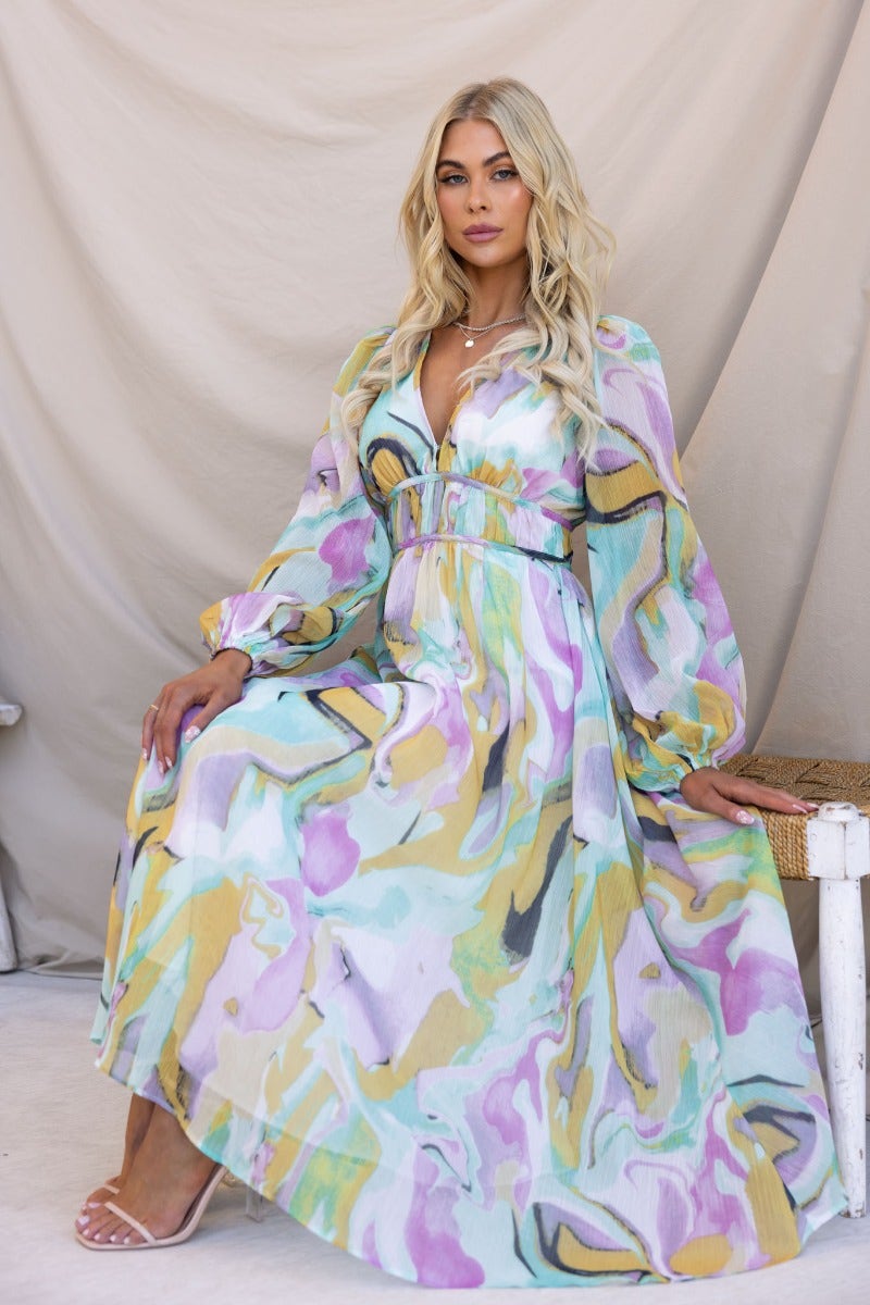 Model wearing the Haelyn Maxi Dress, a multi-coloured print maxi with V-neckline and elastic cuffs.