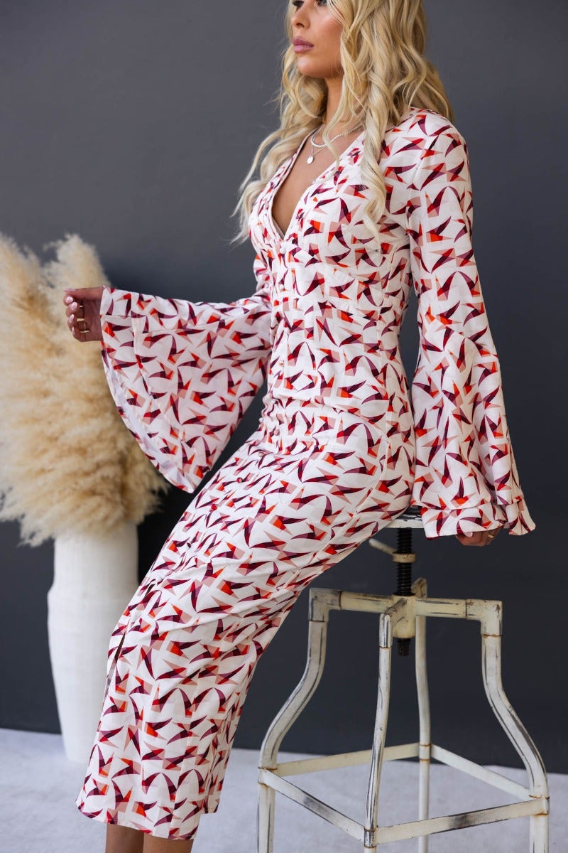 Kiran Maxi Dress with multi-colour print, flare sleeves, and V-neckline, styled by a model in a sophisticated setting.