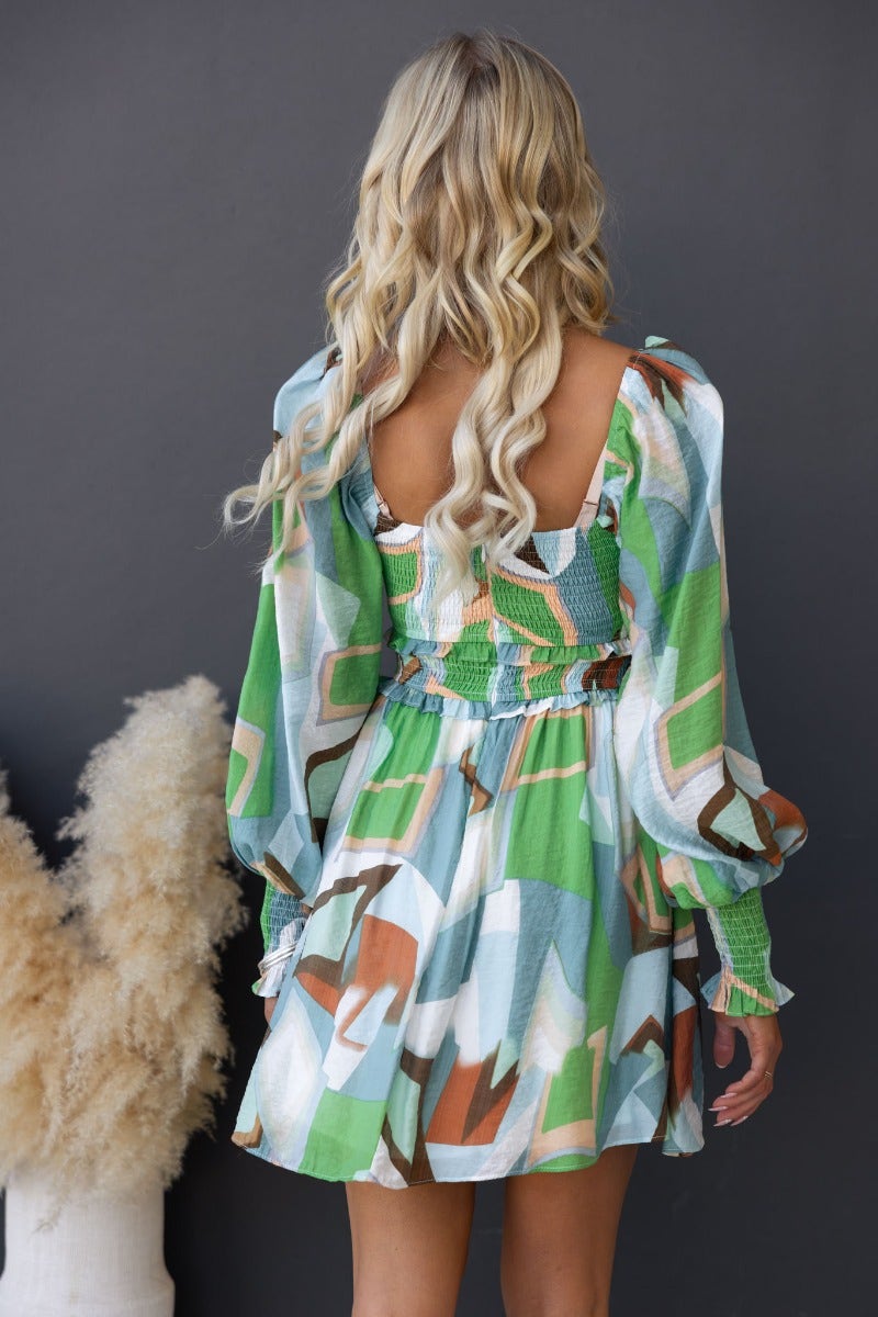 Back view of a multi-colour pistachio dress with elastic cuffs and gathered waist, showcasing stylish pattern and flowy fit.