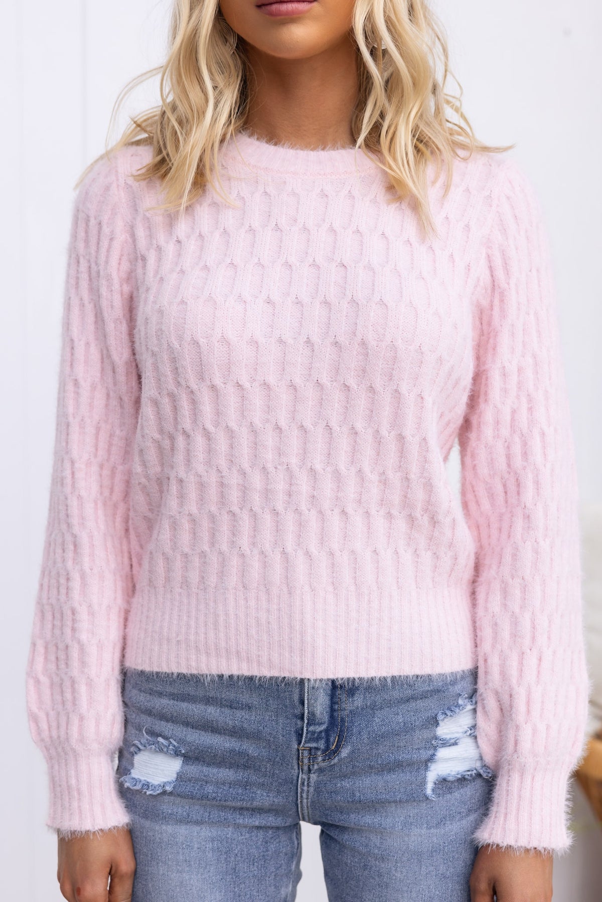 Soft pink Libra Jumper with round neckline and textured fabric, paired with distressed jeans.