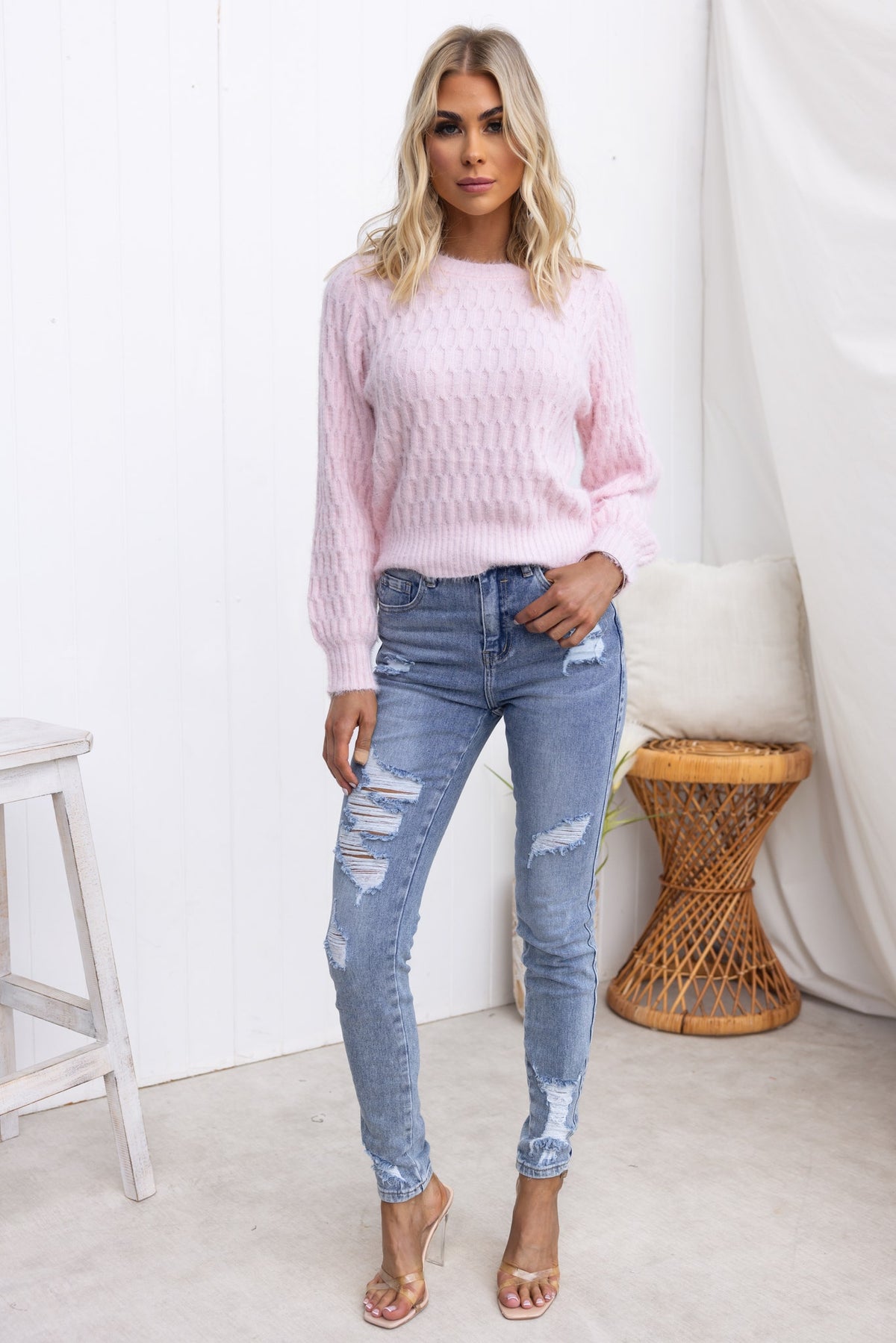 Model wearing a pink Libra Jumper with round neckline, paired with distressed jeans in a stylish indoor setting.