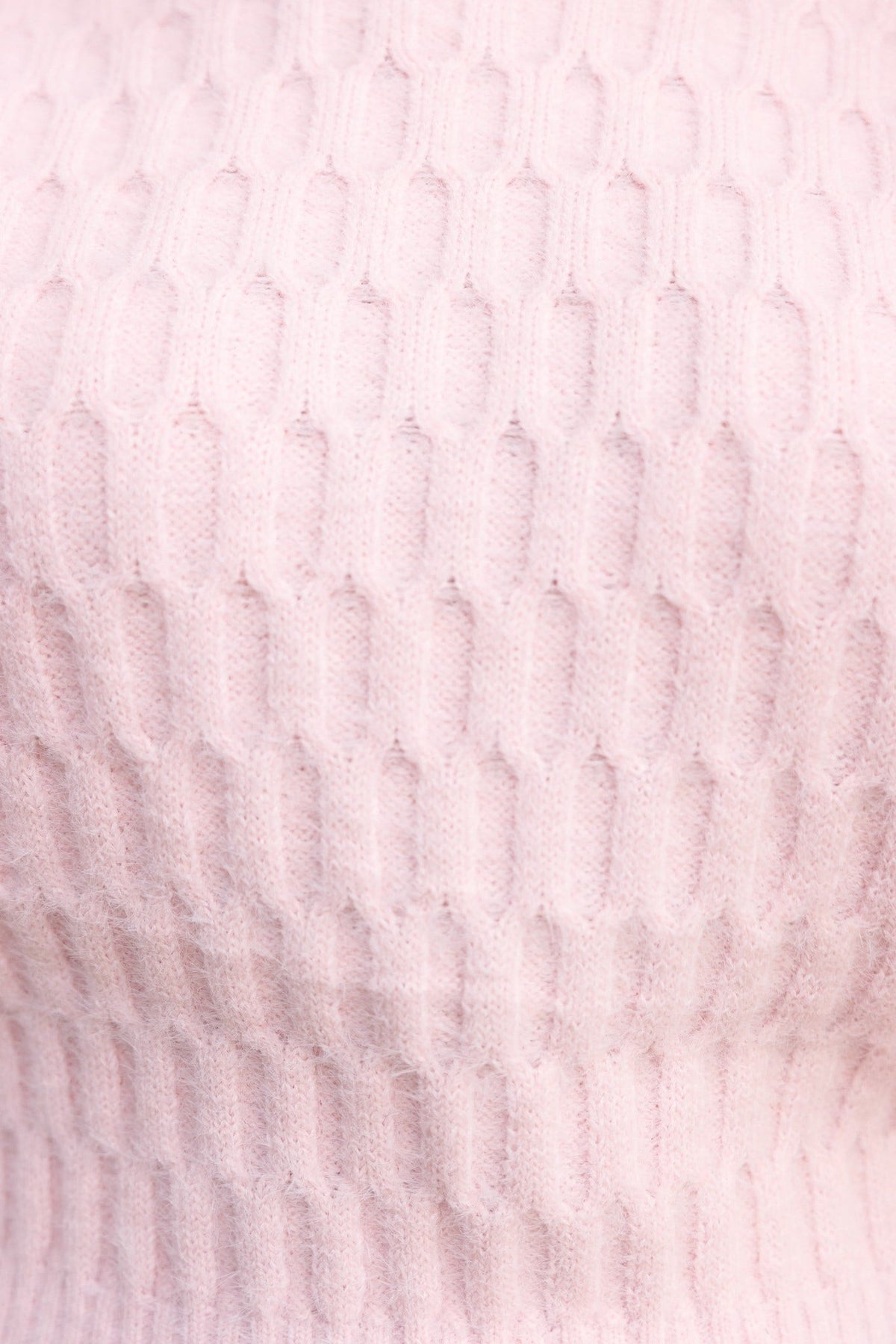 Close-up of soft, fluffy pink fabric with textured pattern from the Libra Jumper, showcasing its cozy material.