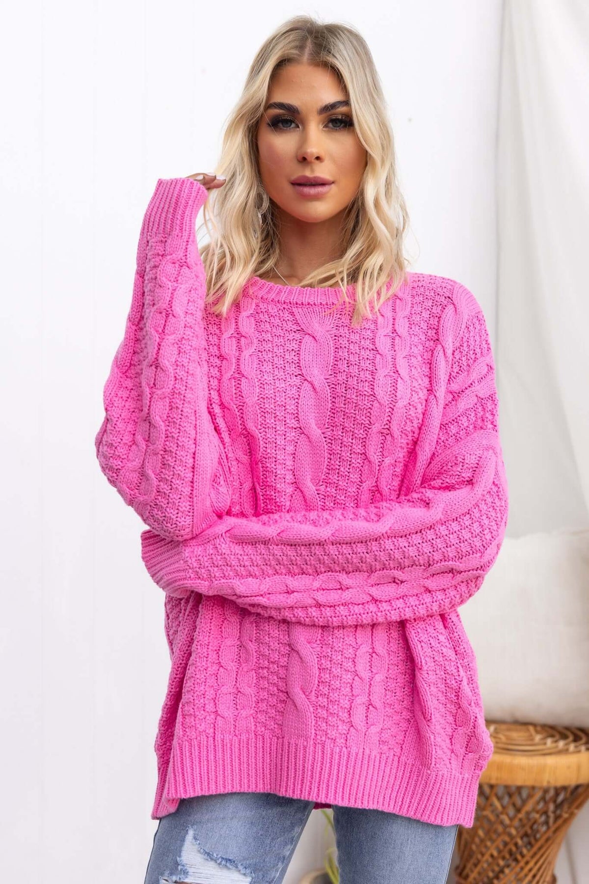 Bright pink Varese jumper with cable knit design and relaxed fit model wearing it, perfect for casual styling.