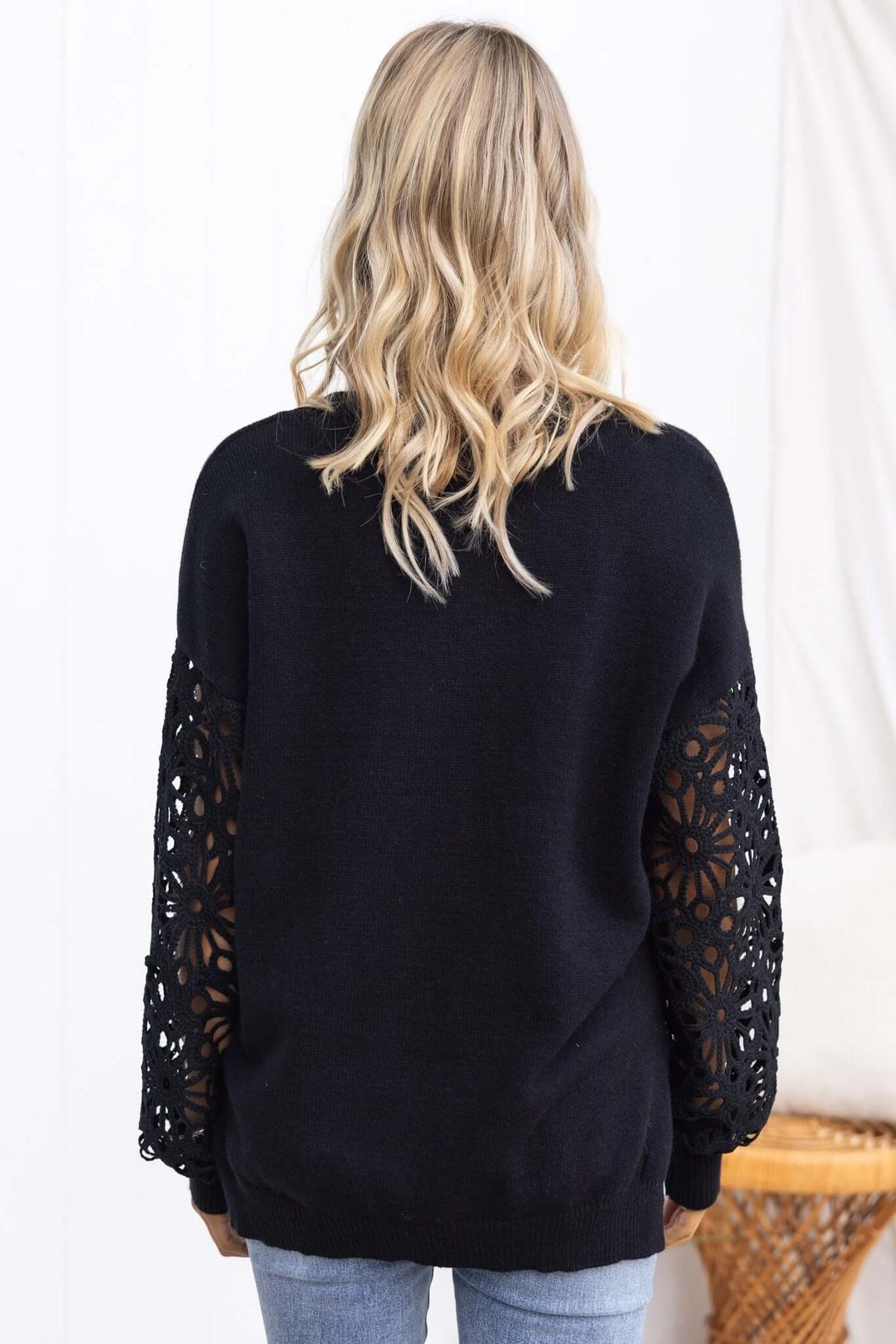 Back view of Mooney Jumper featuring black knit body and crochet sleeves, styled with relaxed fit.