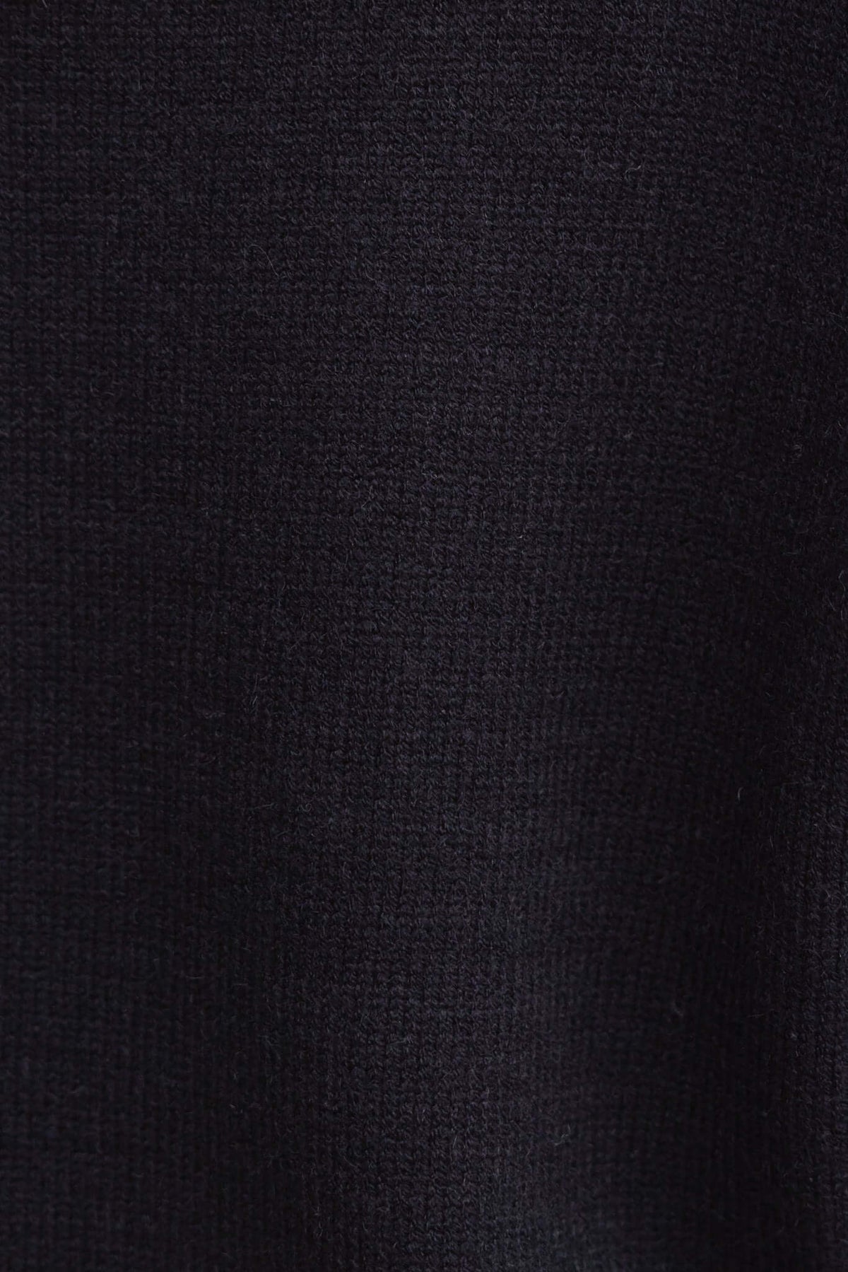 Close-up of the Mooney Jumper in black, showcasing soft knit texture and stretch material.