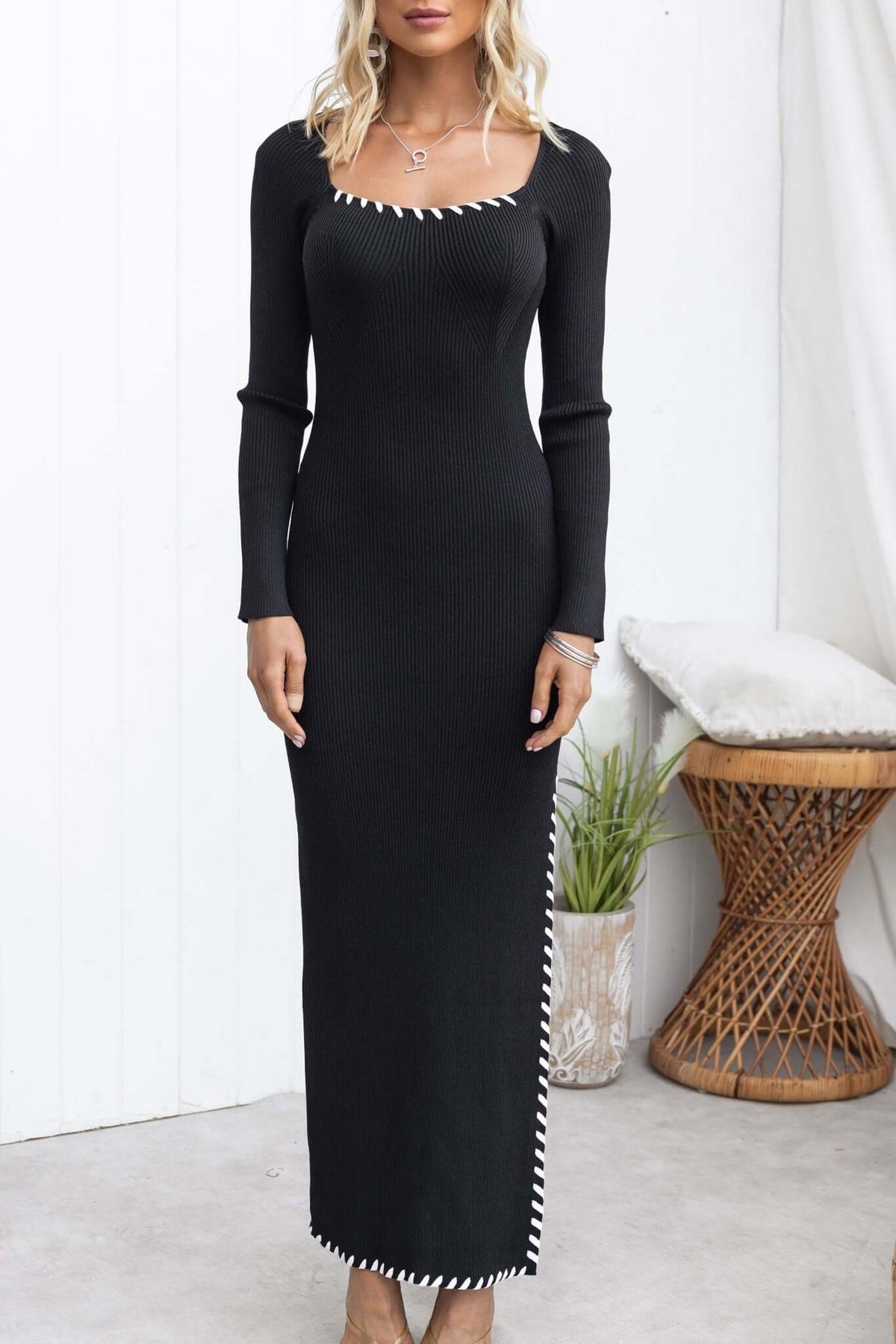 Black Syros Maxi Dress with square neckline, side split, ribbed stretch material, and sleek long sleeves.