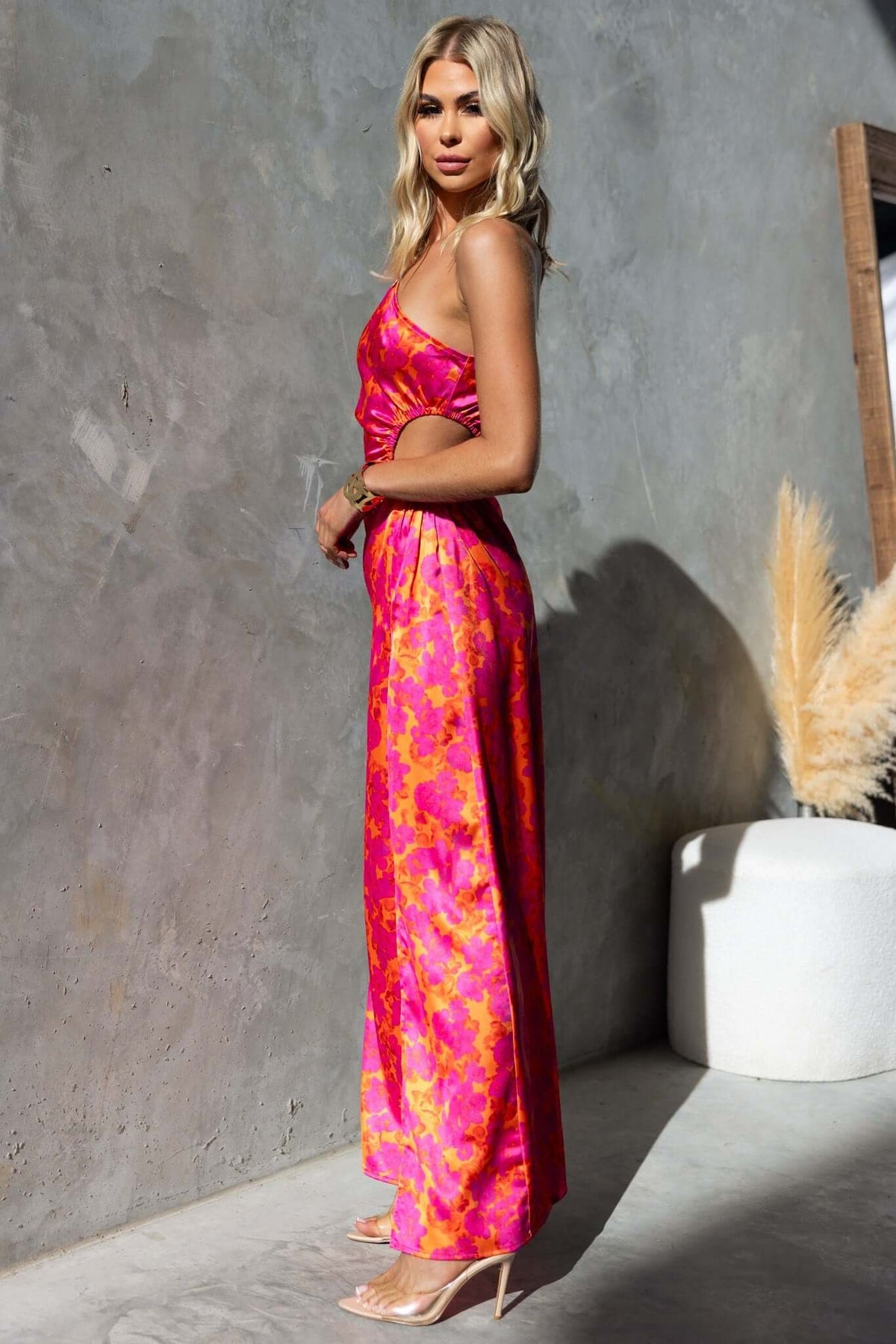 Model wearing a pink floral print Carey Maxi Dress with a one-shoulder neckline and side cut-out.