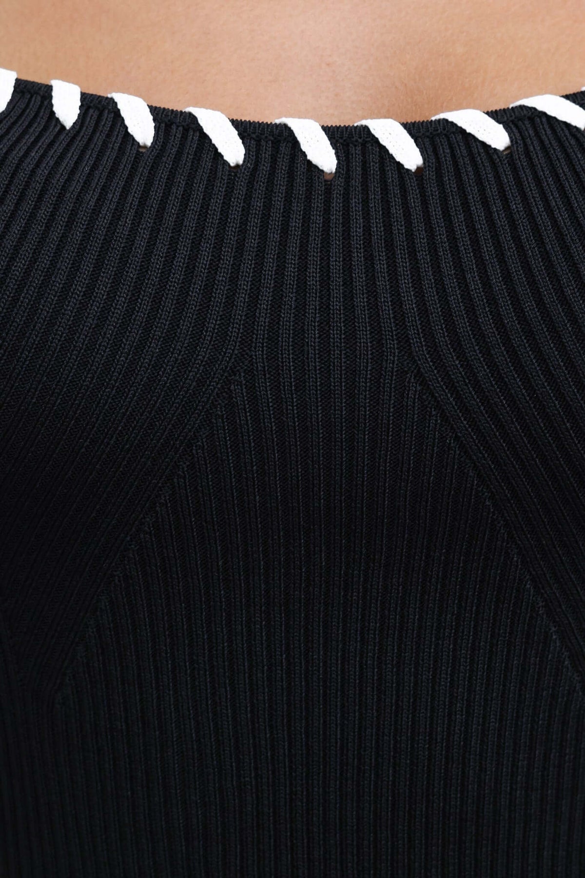 Close-up of the ribbed neckline of the Syros Maxi Dress featuring a black fabric with contrasting white detail.