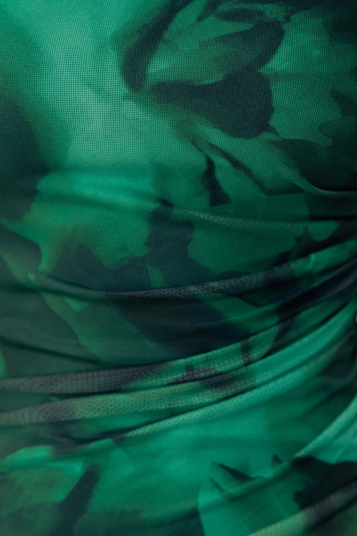 Close-up of the green floral mesh overlay fabric of the Baha Maxi Dress, showcasing its bodycon design and texture.