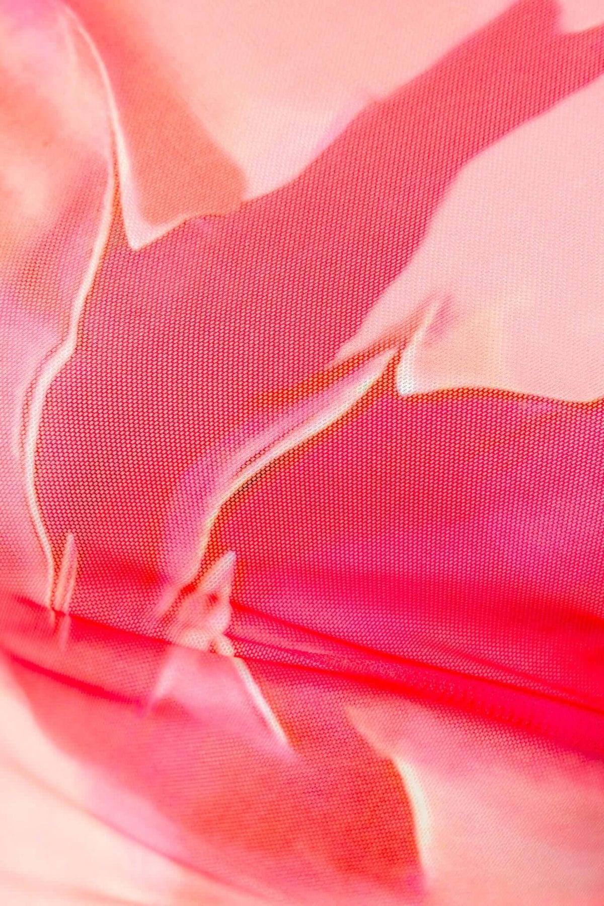 Close-up of the pink mesh fabric of the Baha Maxi Dress, showcasing vibrant colors and intricate design details.
