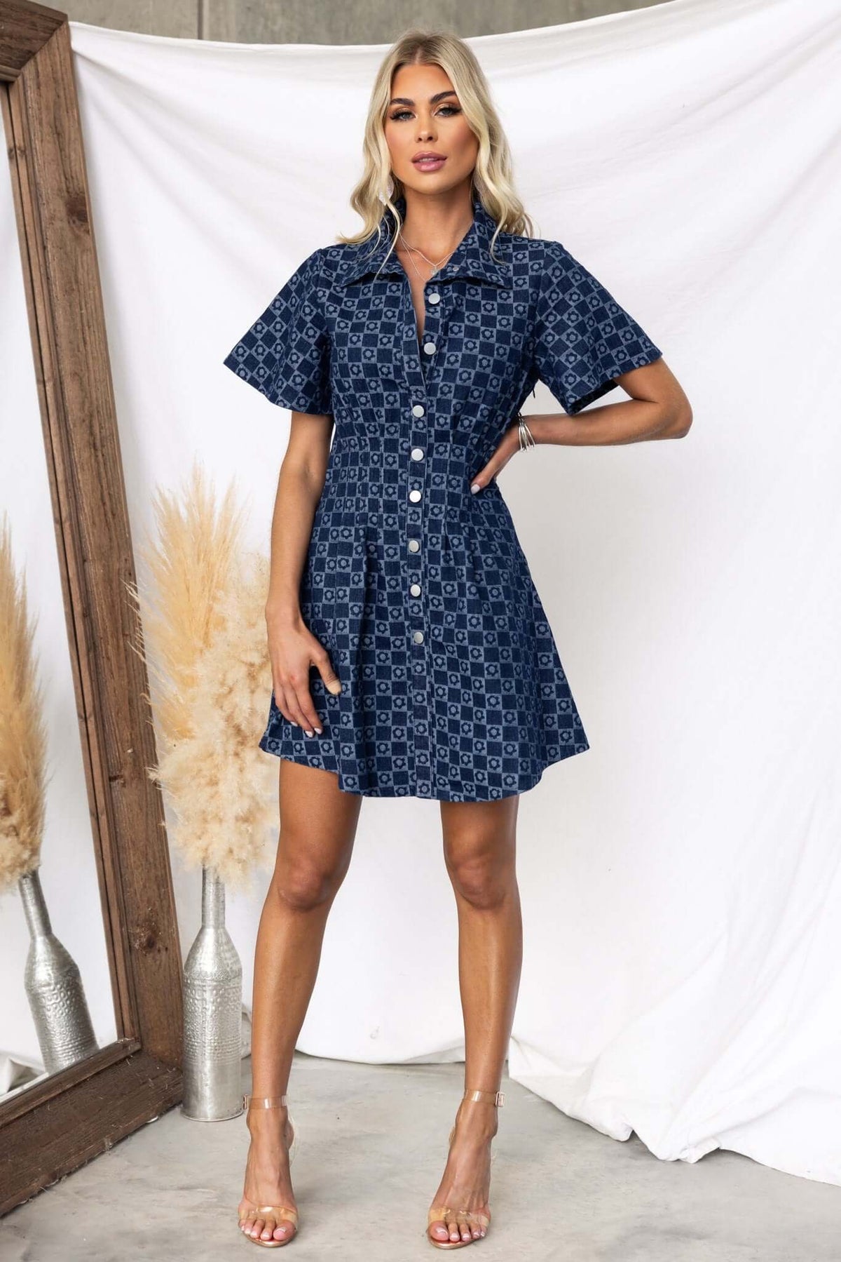 Model wearing a stylish Mara denim dress with a collar and faux button-up front, showcasing a chic and casual look.