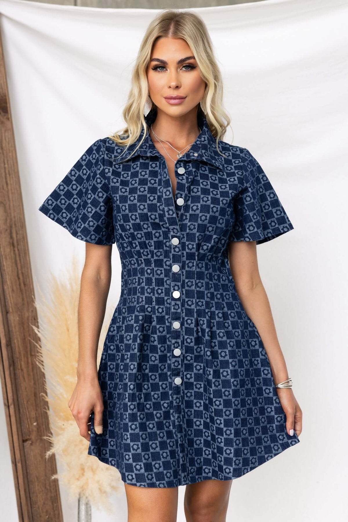 Model wearing the Mara Denim Dress, a stylish button-up denim dress featuring a collar and short sleeves.
