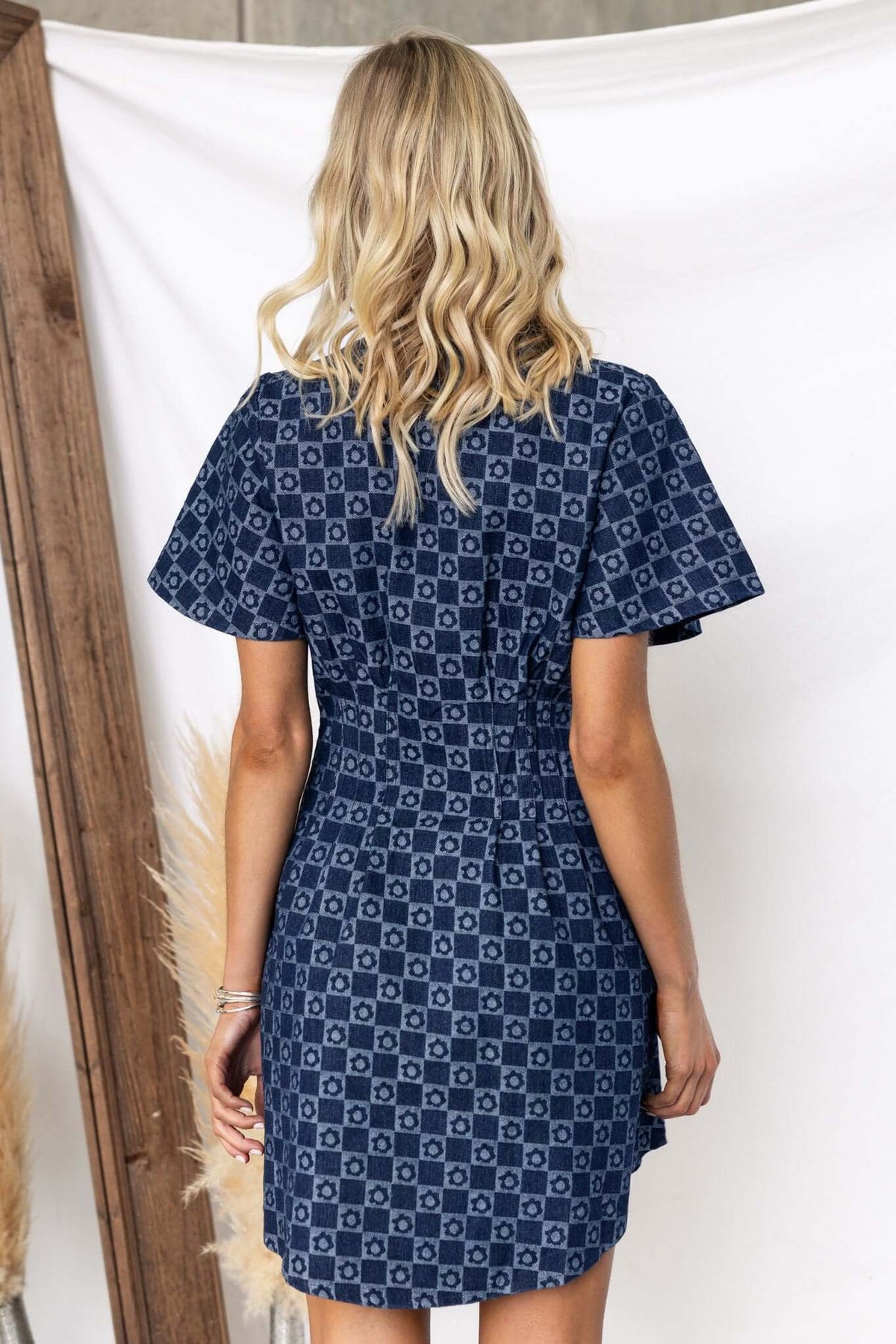 Back view of Mara Denim Dress featuring a collar, short sleeves, and a stylish patterned design.