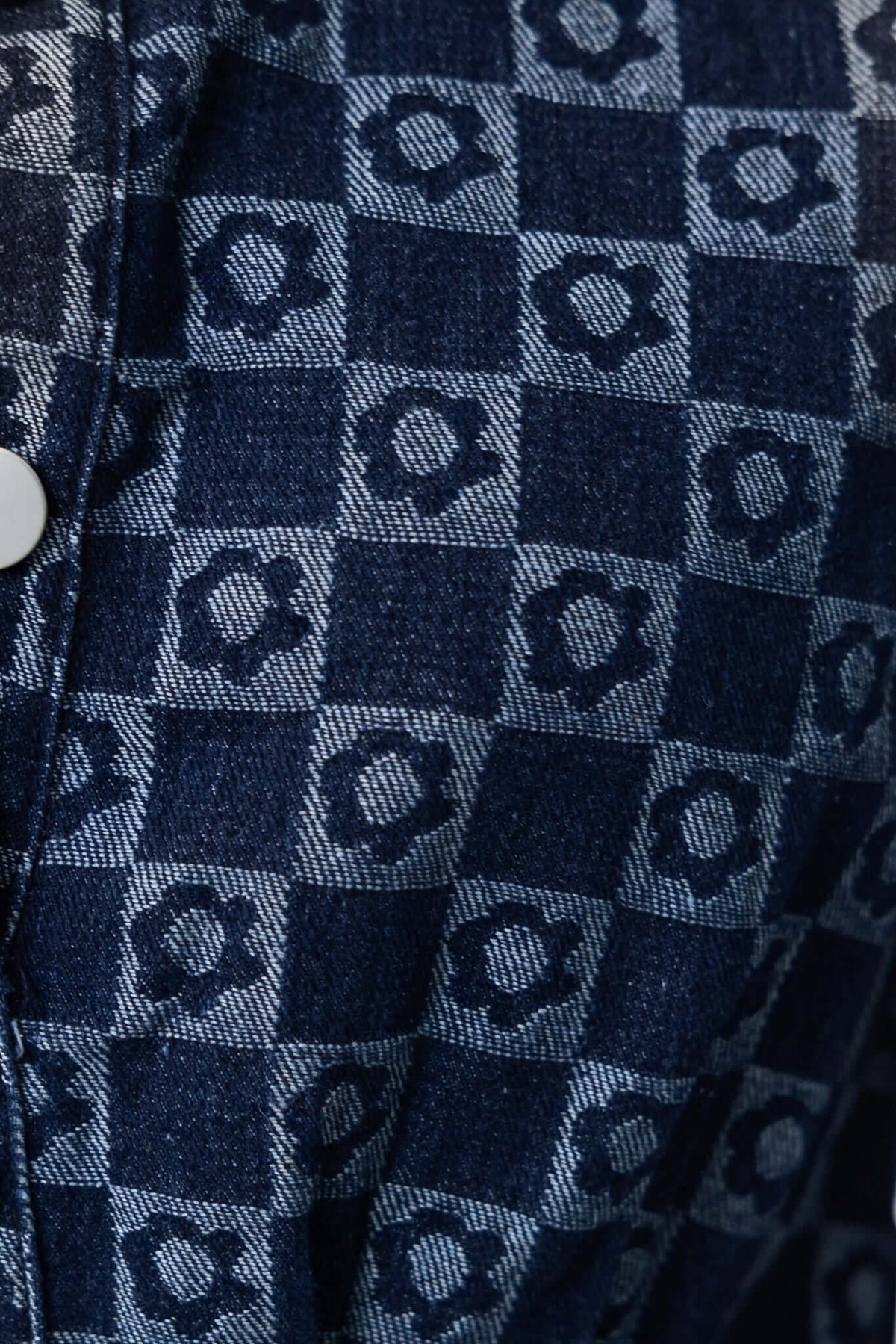 Close-up of Mara Denim Dress fabric, featuring a blue checkered pattern with circular designs.