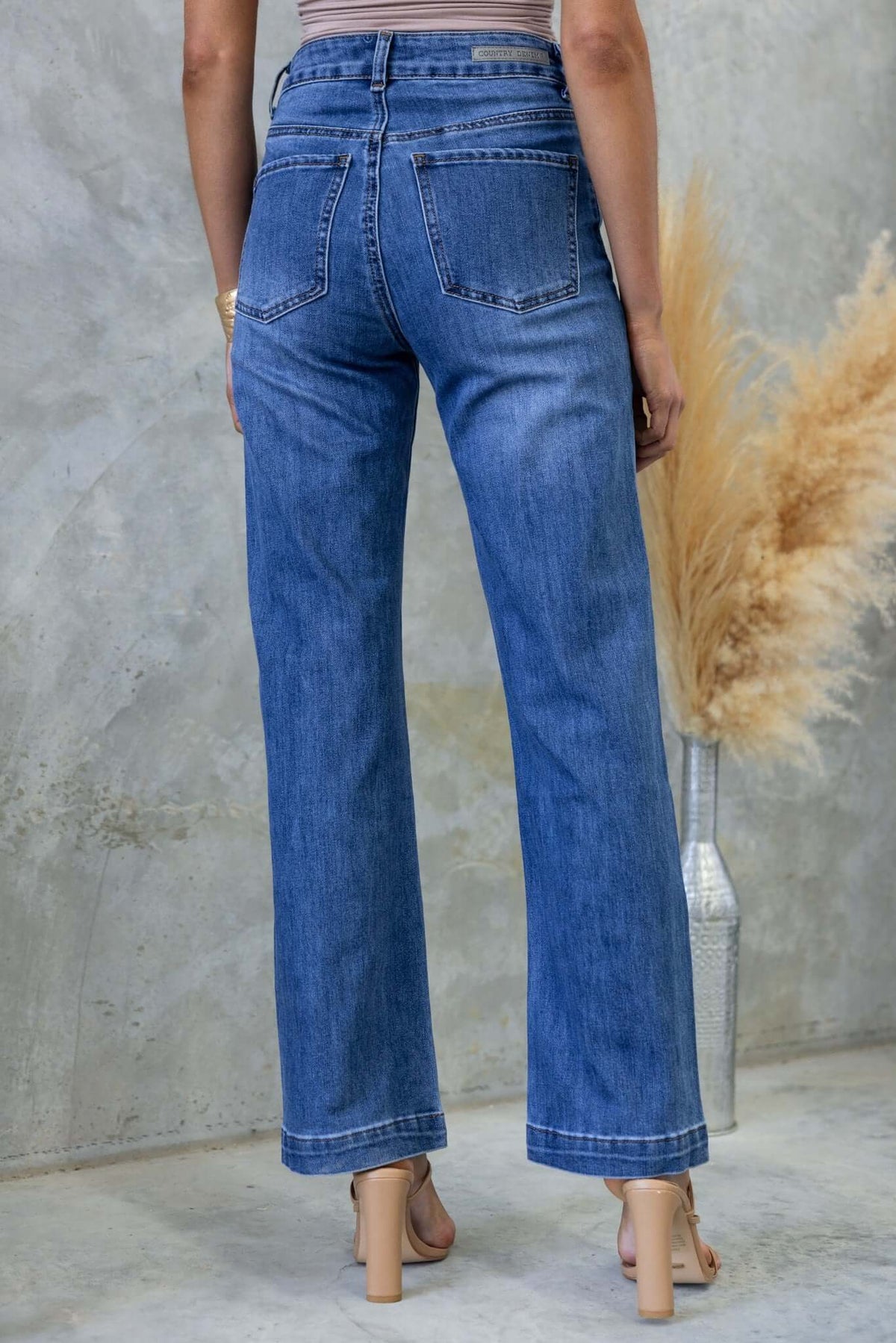 Model wearing Tonic Jeans, showcasing the back view with a mid-high waist, straight leg fit, and pockets.
