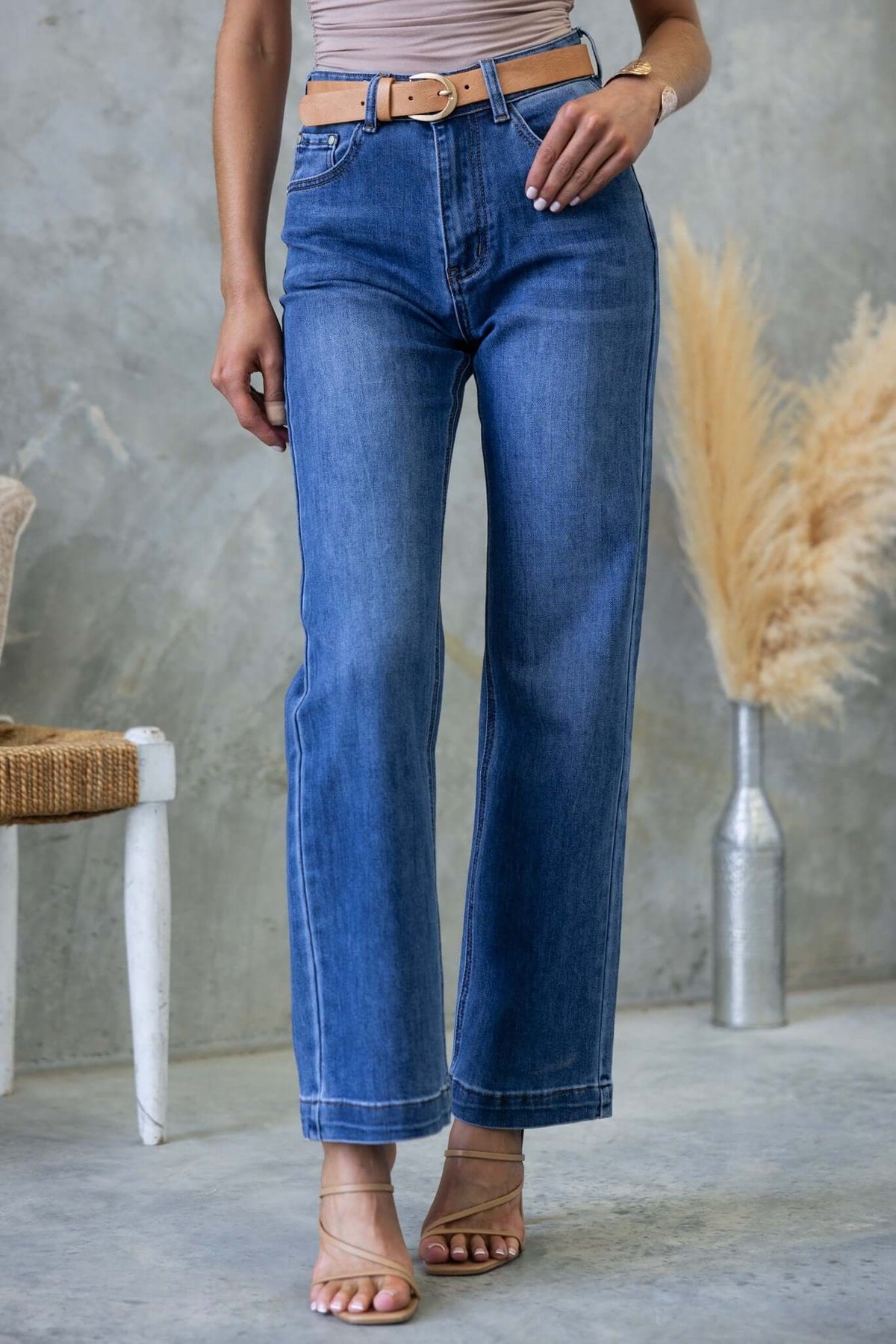 Model wearing Tonic Jeans with mid-high waist, straight leg fit, styled with a belt and minimalist sandals.