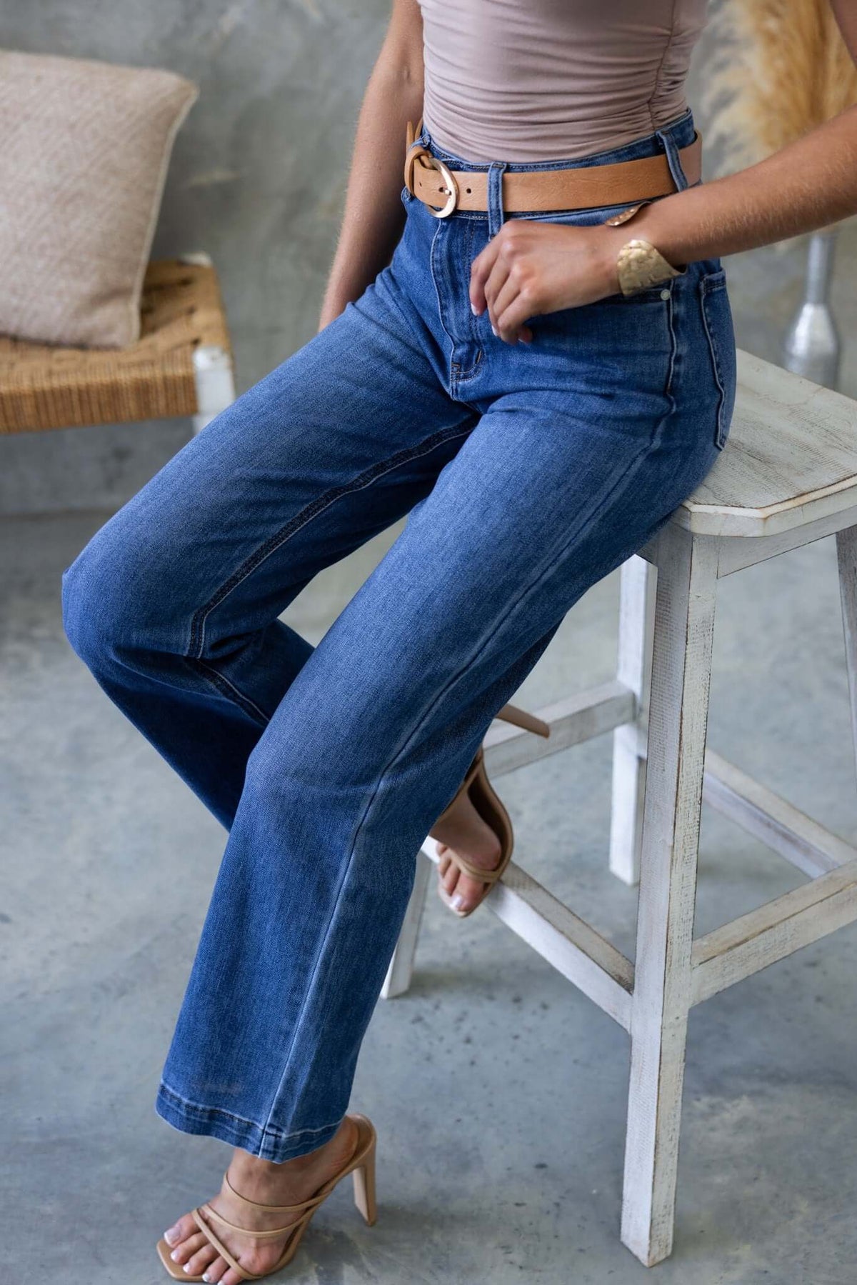 Model wearing Tonic Jeans, mid-high waist denim with straight leg fit, styled with a belt and sandals.