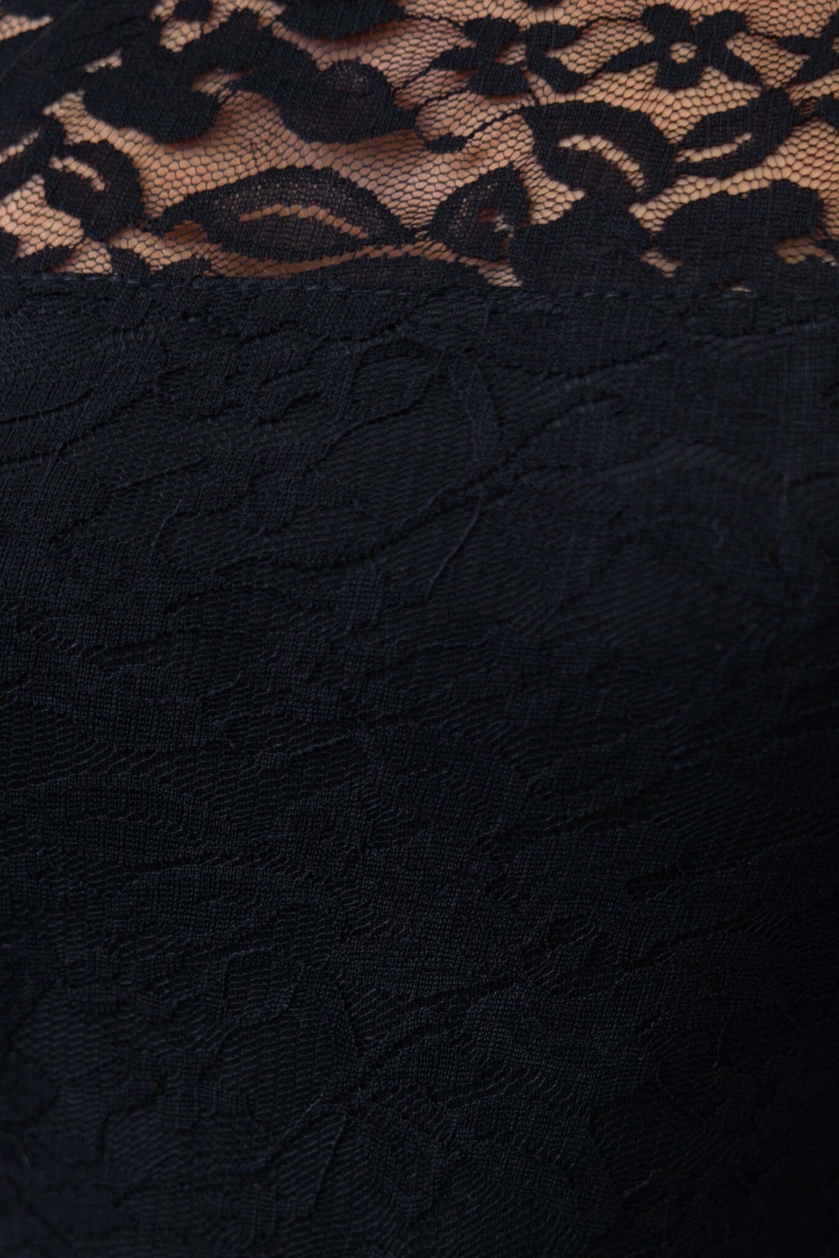 Close-up of black lace fabric featuring intricate floral pattern, part of the Trend Setter Bodysuit collection.
