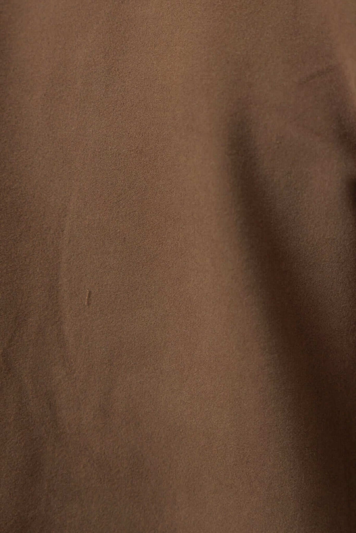 Close-up of soft suede-like fabric in brown, showcasing texture and color for the Aria Coat.