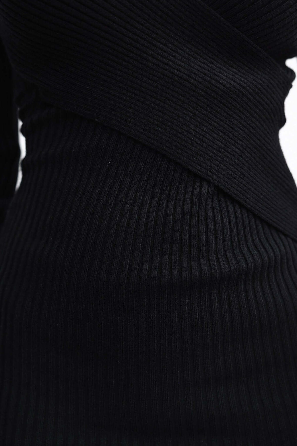 Close-up of the Mikka Midi Dress in black, showcasing its ribbed knit texture and V-neckline design.