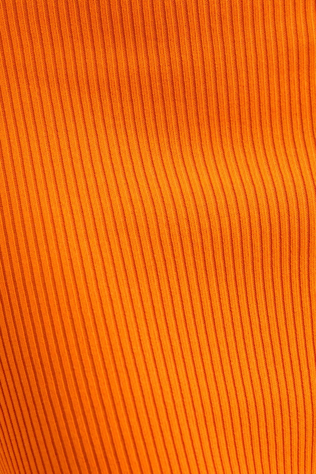 Close-up of vibrant orange ribbed knit fabric, showcasing texture ideal for the Fiery Midi Dress.