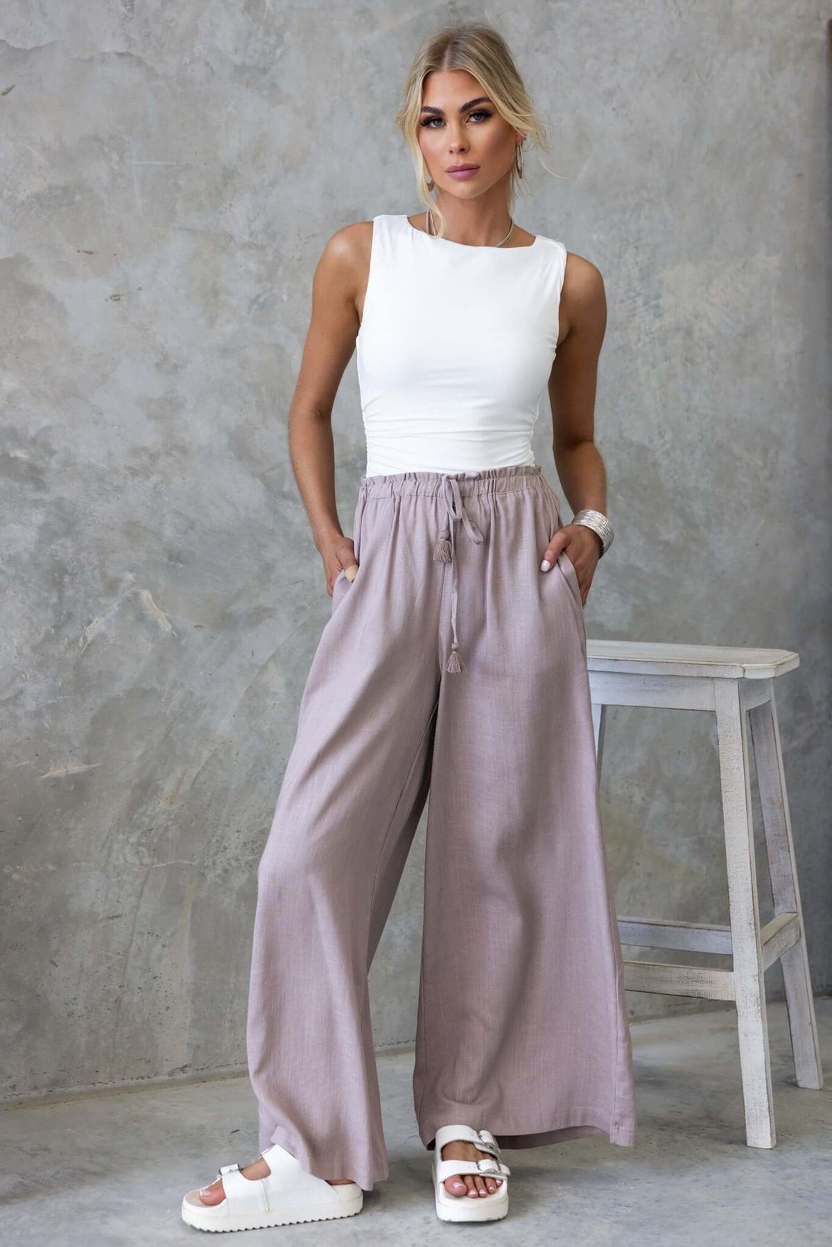 Model wearing Marcia Pants with mid-high waist, elastic drawstring, and pockets in a stylish atmosphere.