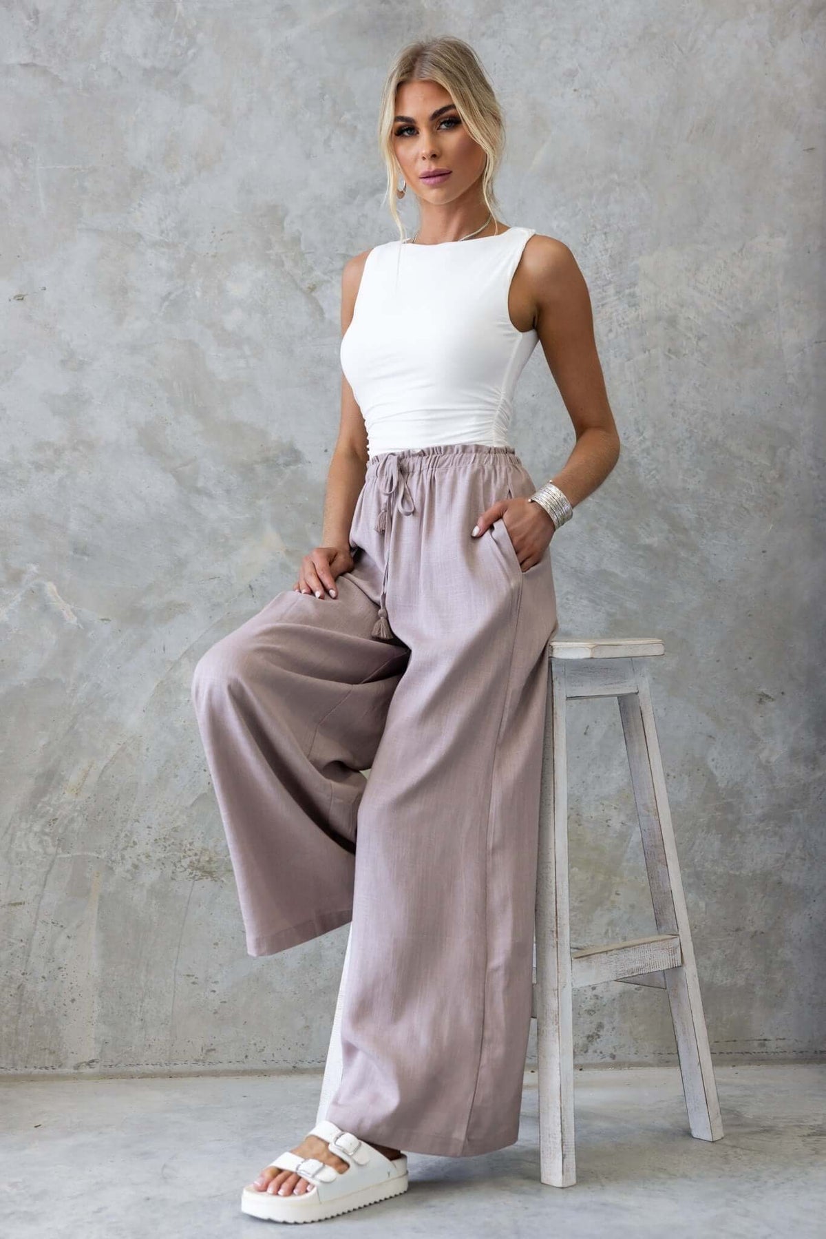 Model wearing Marcia Pants with a mid-high waist and elastic waistband, styled with a fitted white top.