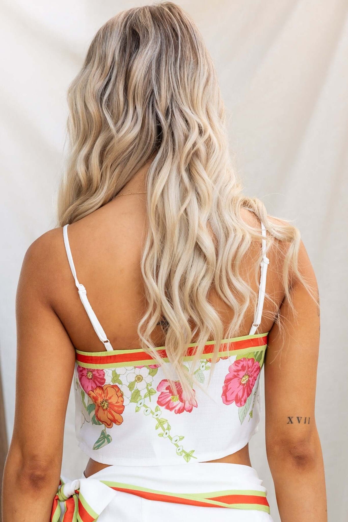 Back view of a woman wearing the Julissa Top with floral design and adjustable straps, showcasing a casual summer style.