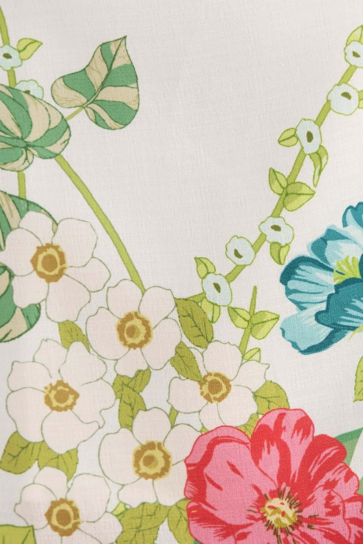 Colorful floral pattern featuring blue, pink, and green flowers on a white background, ideal for summer apparel.