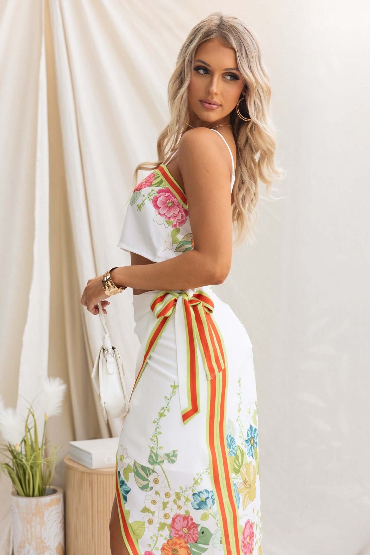 Julissa Wrap Midi Skirt featuring floral design, wrap style, and attached tie, displayed elegantly by a model.