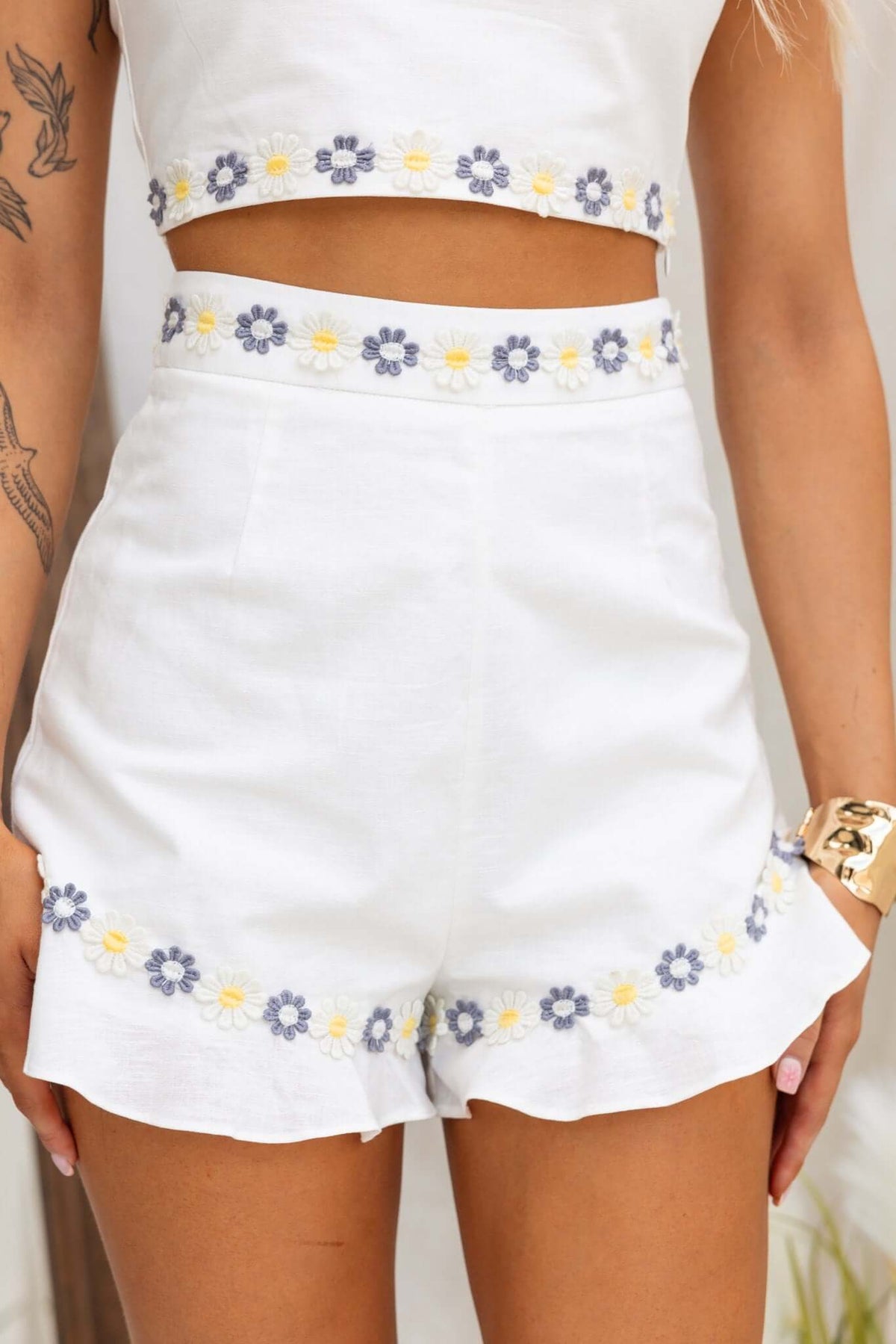 Picnic Dreams Shorts featuring a mid-high waist, floral embroidery, and a ruffled hem in 100% linen.