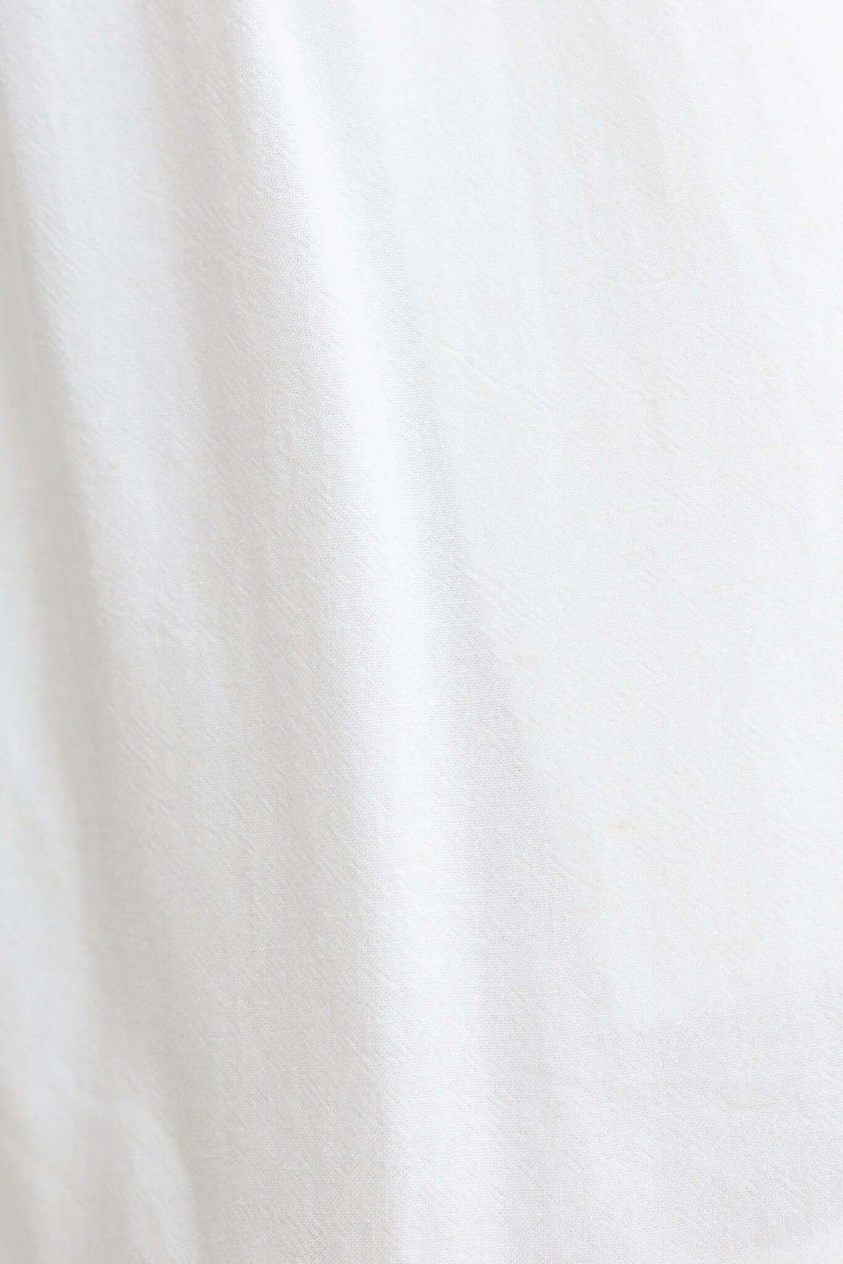 Close-up of soft, light white fabric texture, ideal for Mayok Shorts with 80% linen and 20% cotton composition.