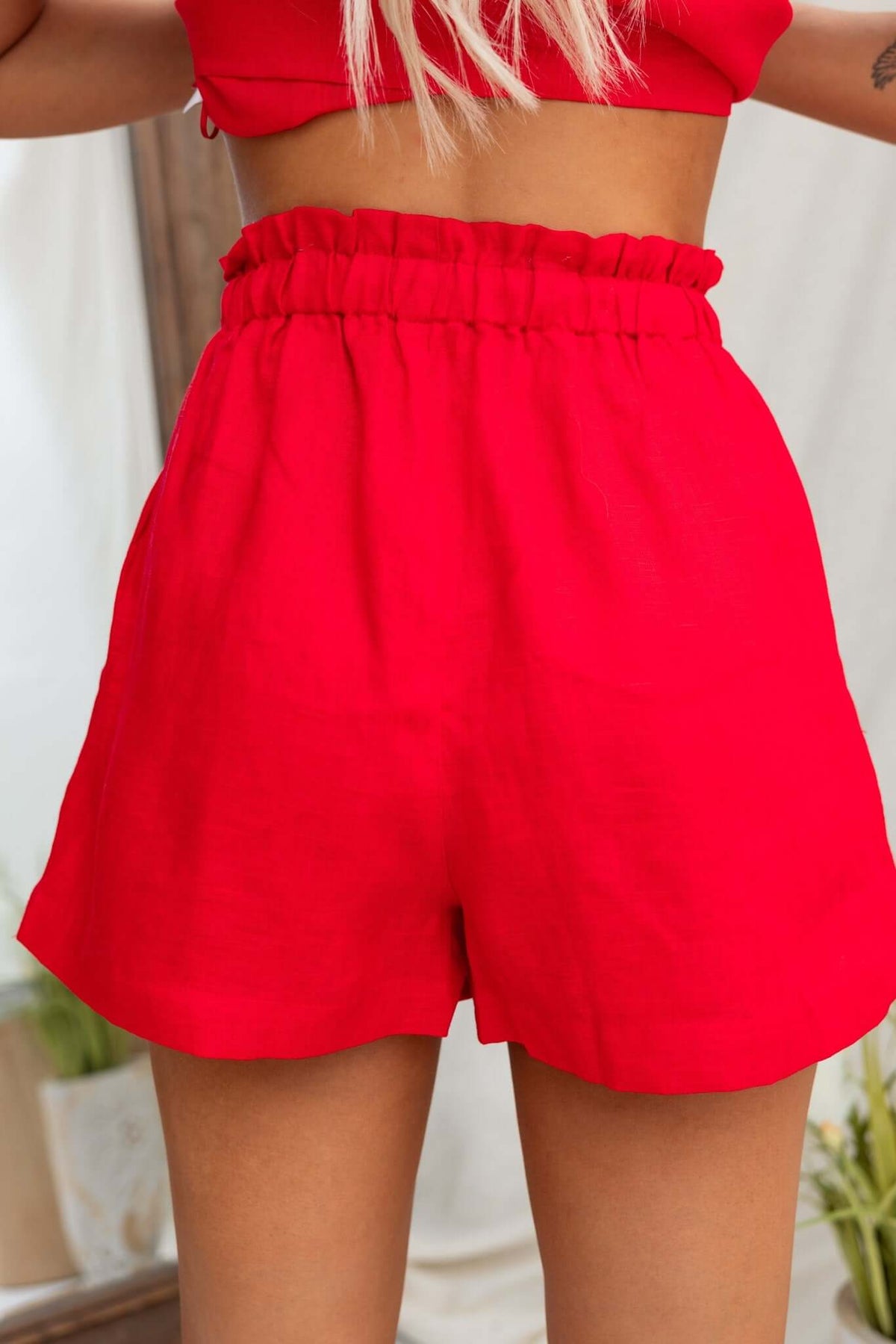 Back view of red Orson Shorts featuring an elastic waistband and mid-high waist fit, made of 100% linen.