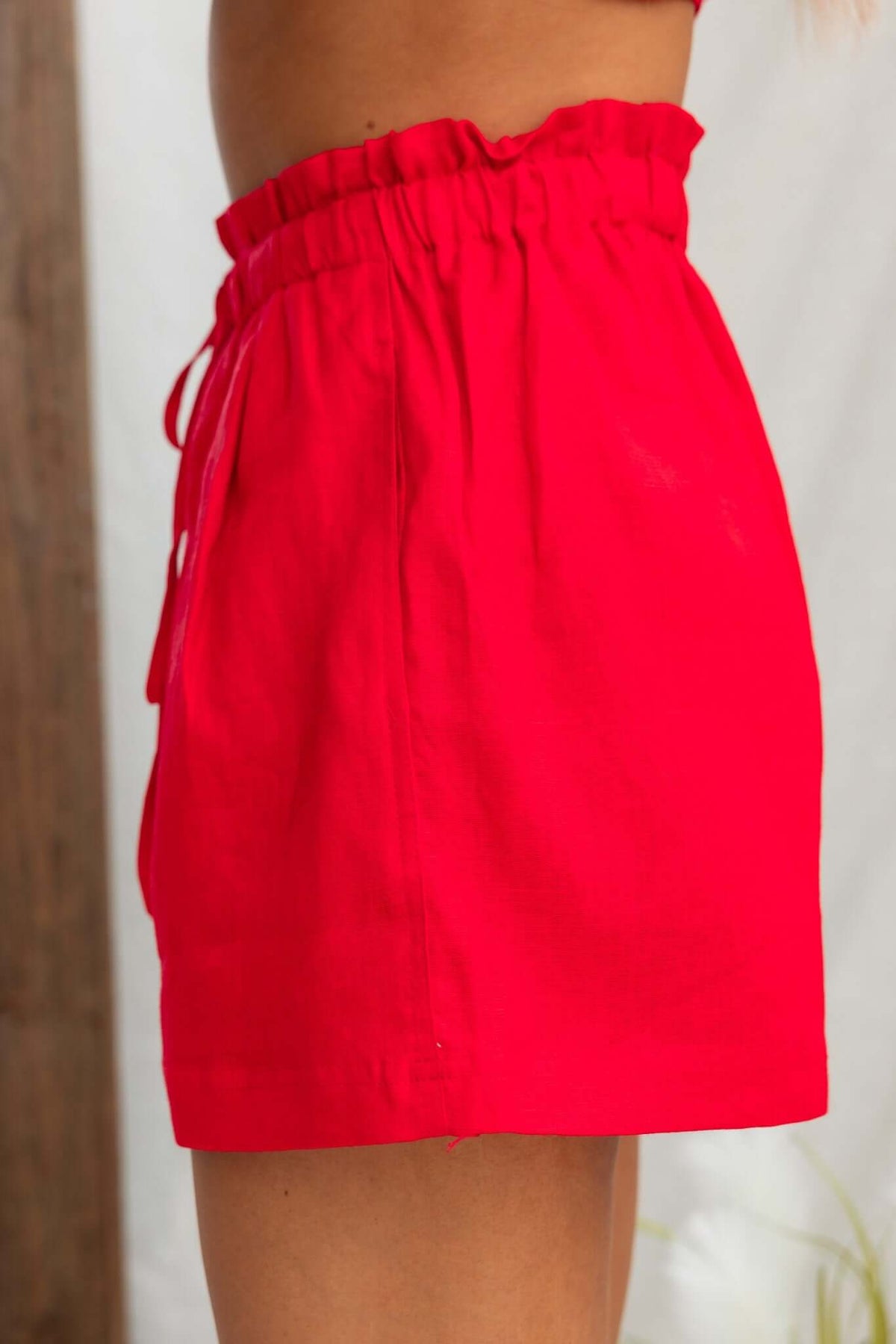 Side view of Orson Shorts featuring a mid-high waist fit, elastic waistband, and vibrant red color.