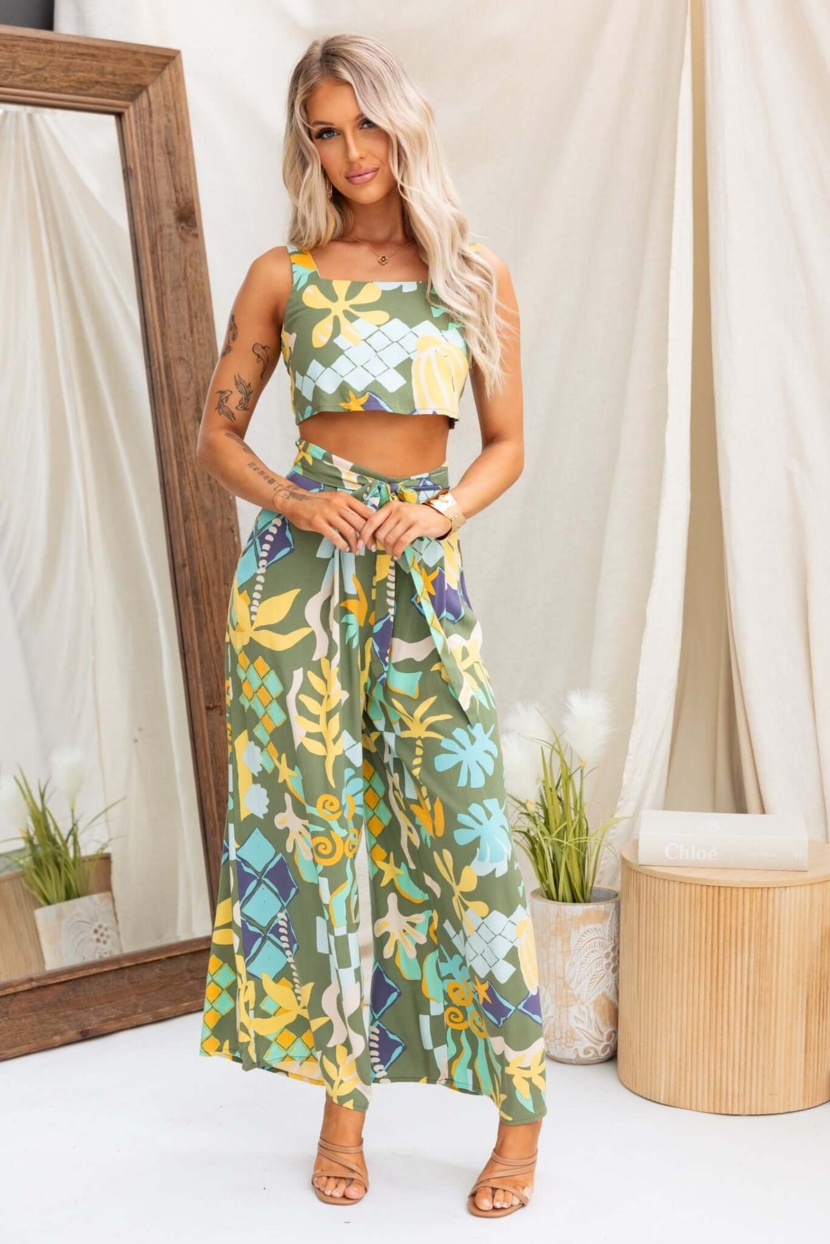 Model wearing Warana Pants with mid-high waist, removable tie, and pockets in vibrant floral print.