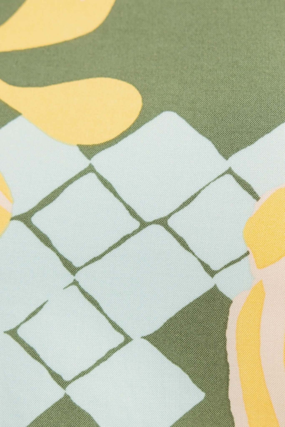 Close-up of Warana Pants fabric featuring floral patterns in green, yellow, and blue hues.