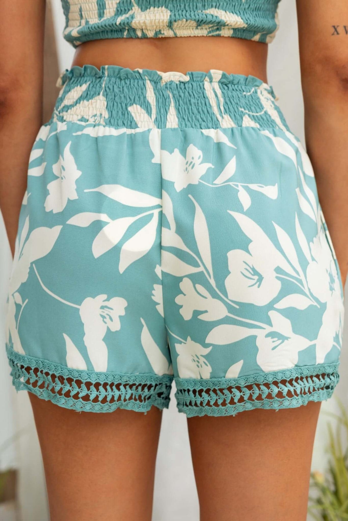 Istory Shorts in blue floral print with elastic waistband and crochet trim, perfect for summer styling.