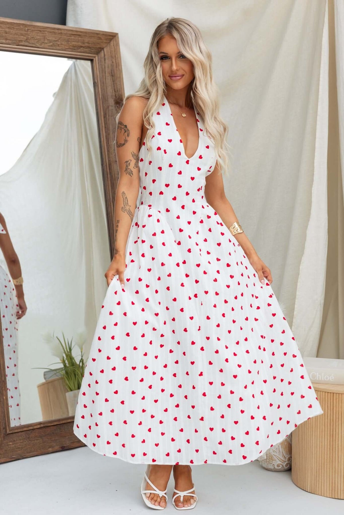 Woman wearing Imarnie Maxi Dress with tie neckline and heart pattern, featuring a tulle underlay and elegant styling.
